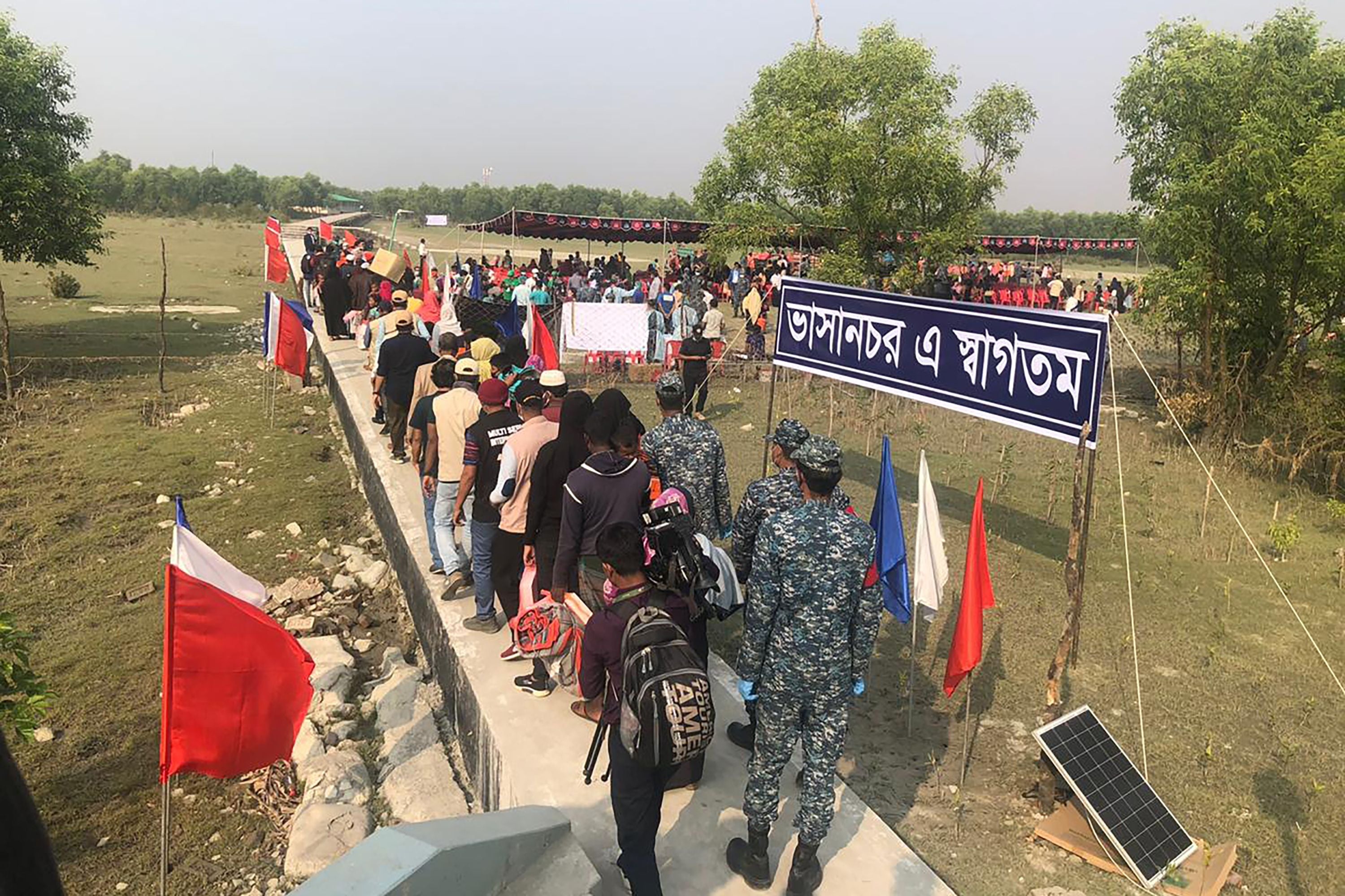 Rohingya refugees stand in a queue after disembarking from a Bangladesh Navy ship to the island of Basan Char