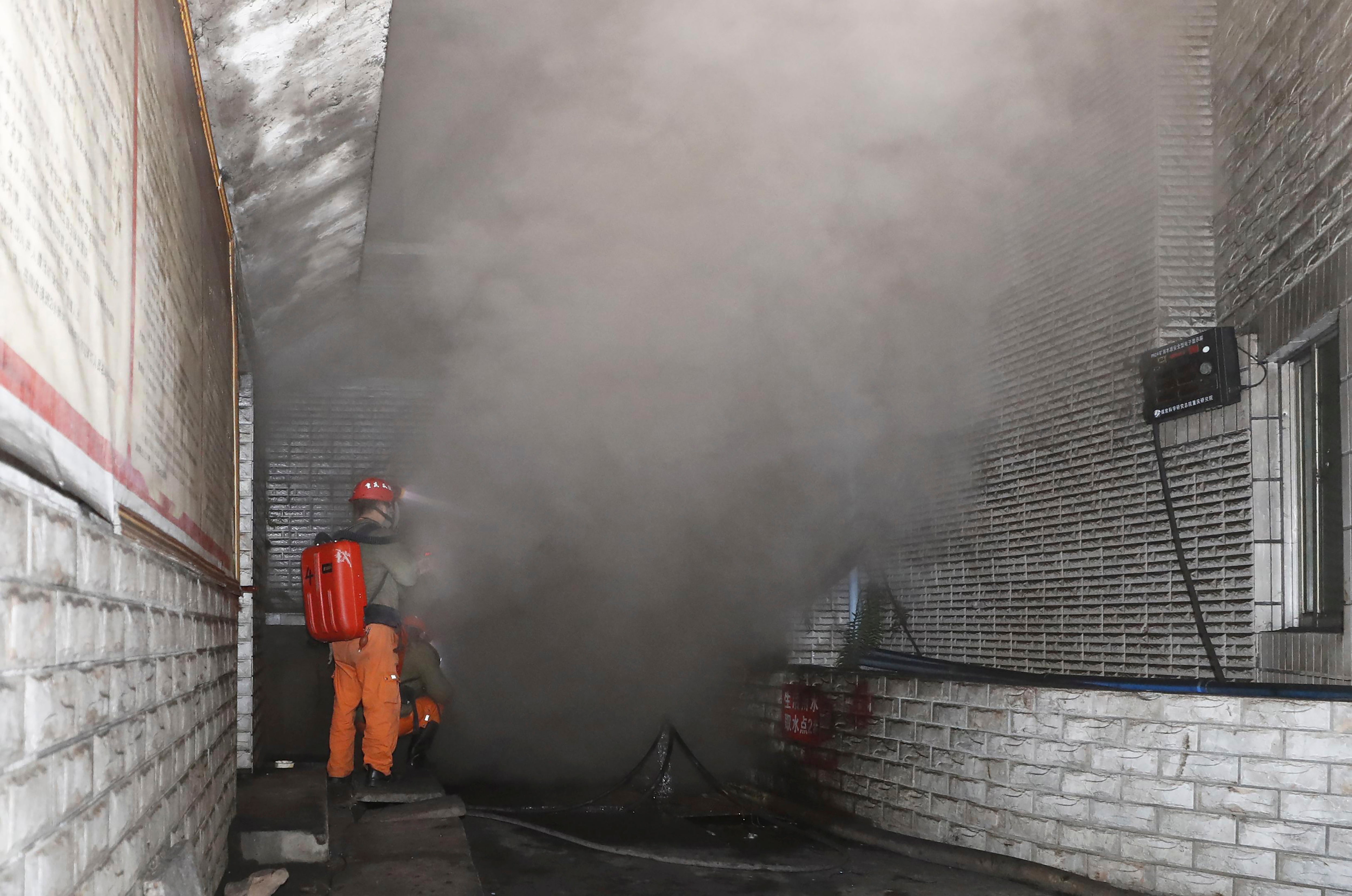 Rescue workers at the entrance of the coal mine in Yongchuan District of Chongqing, southwestern China