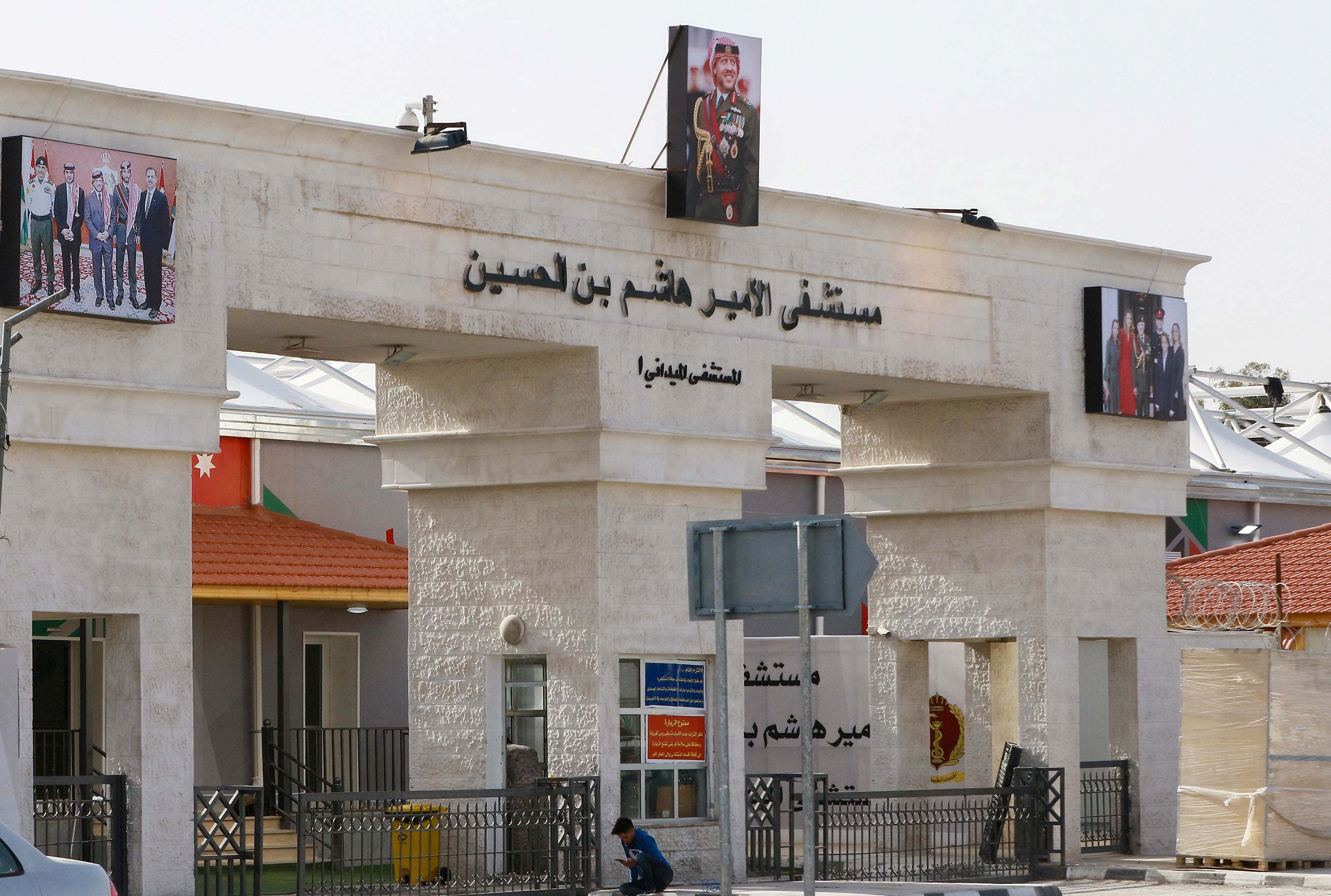 A boy sits in front of the main entrance of the Prince Hashem bin Hussein field hospital, Jordan’s first Covid-19 field hospital, in the city of Zarqa, east of the capital Amman. (Photo by KHALIL MAZRAAWI/afp/AFP via Getty Images)