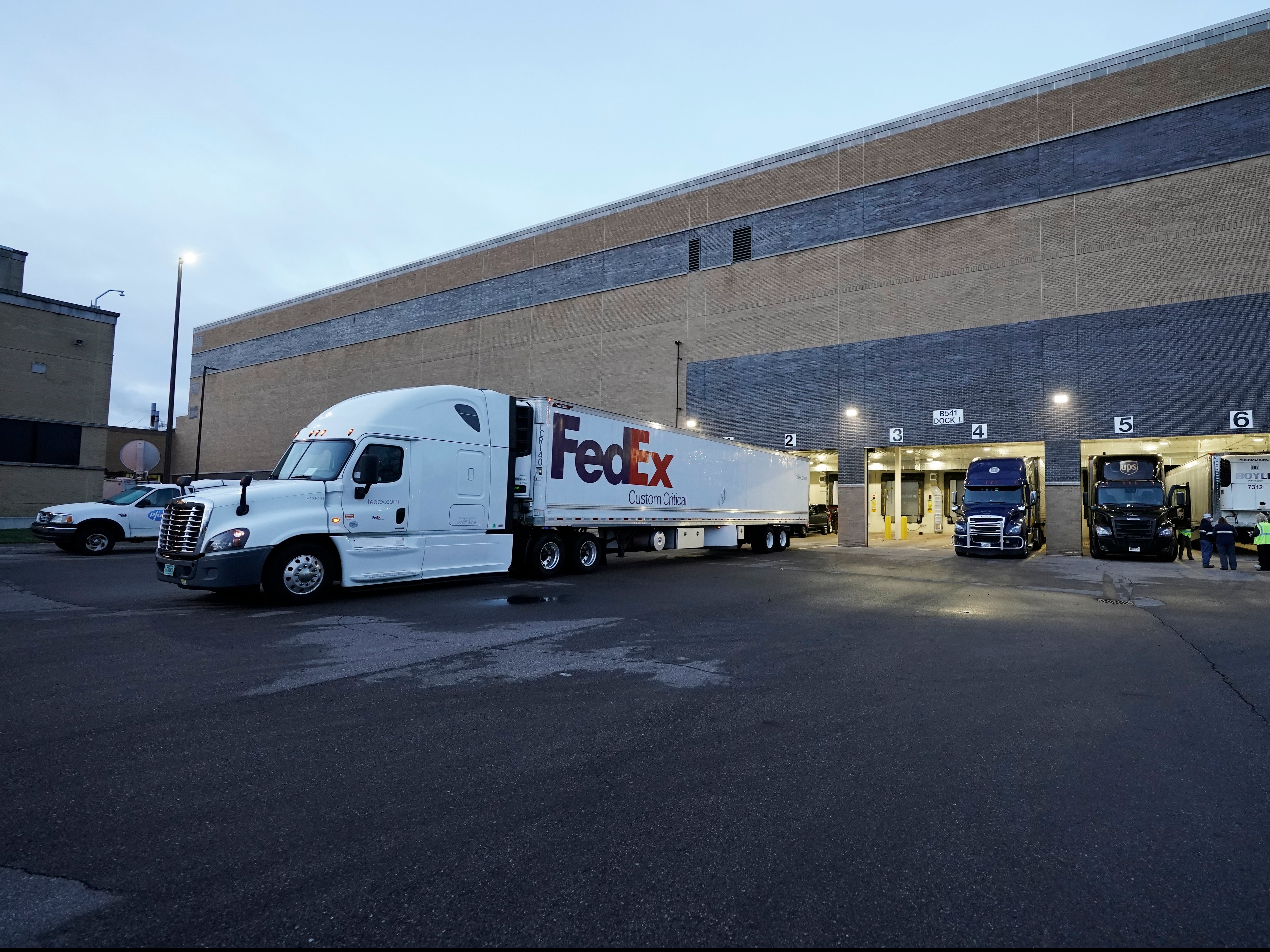 A truck loaded with vaccine leaves the Pfizer plant in Portage, Michigan