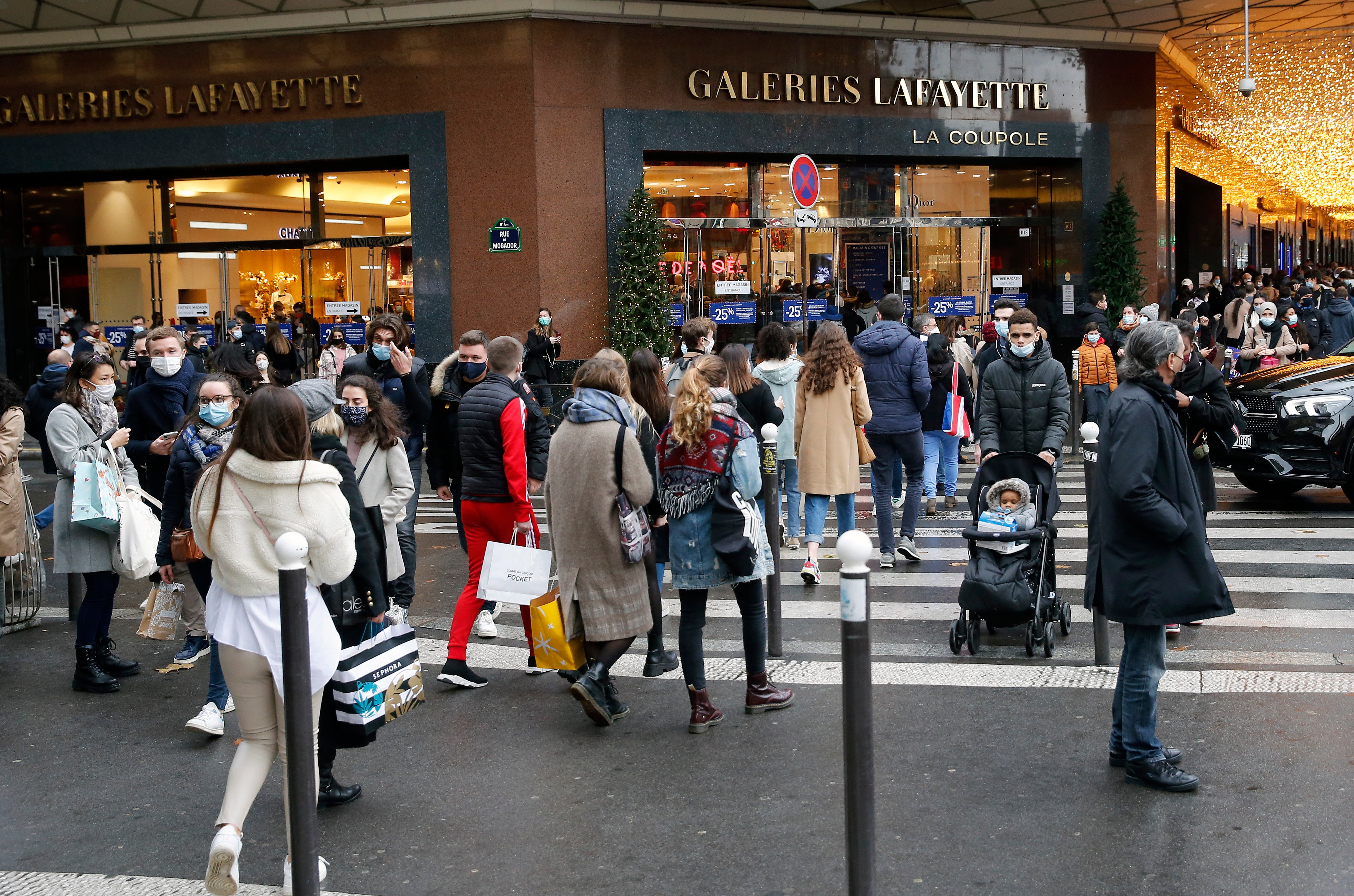 People wearing protective face masks shopping without respecting the social distancing instructions recommended by the French government on 19 December in Paris