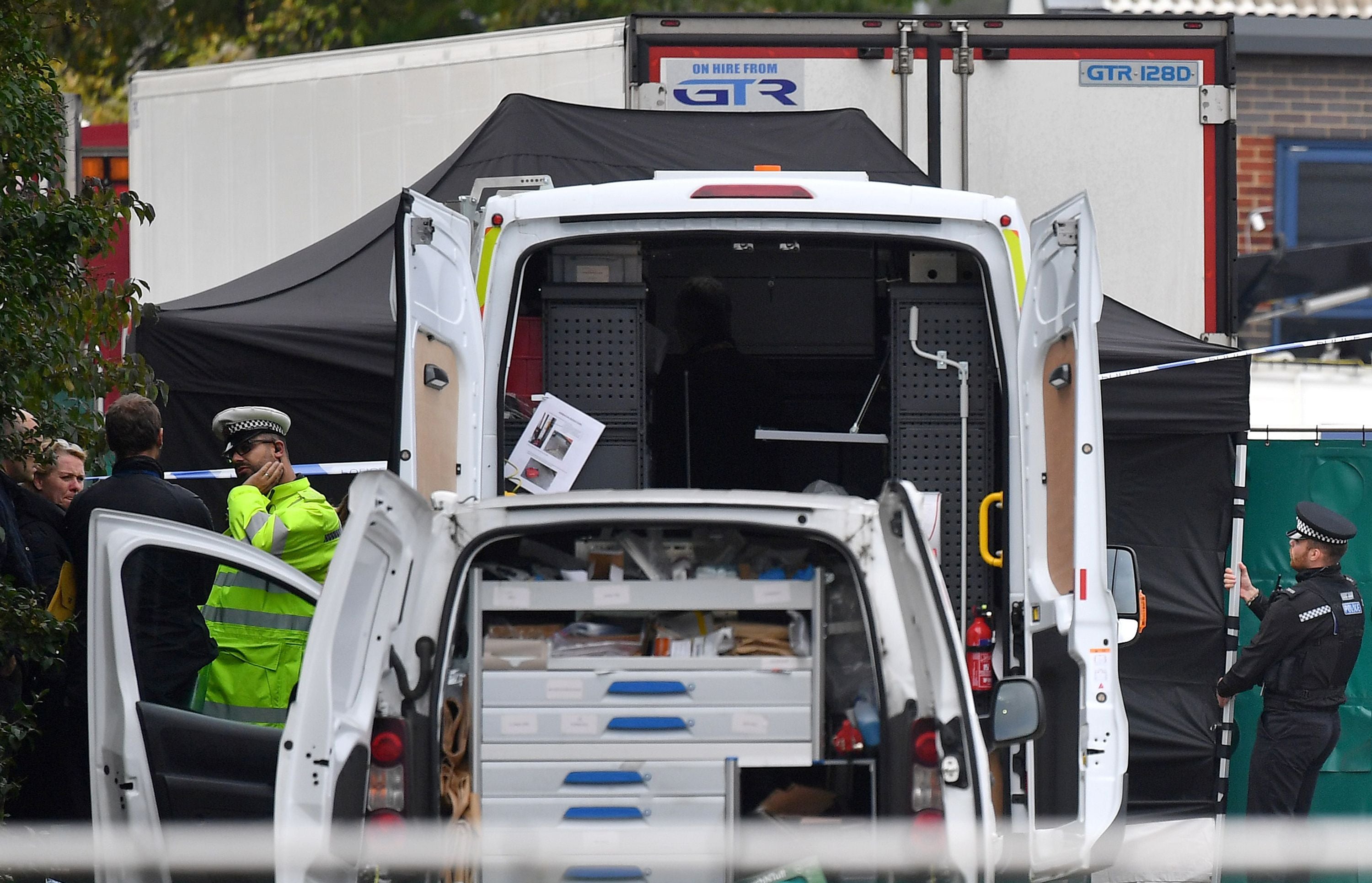 Police officers working near the lorry that contained 39 dead bodies