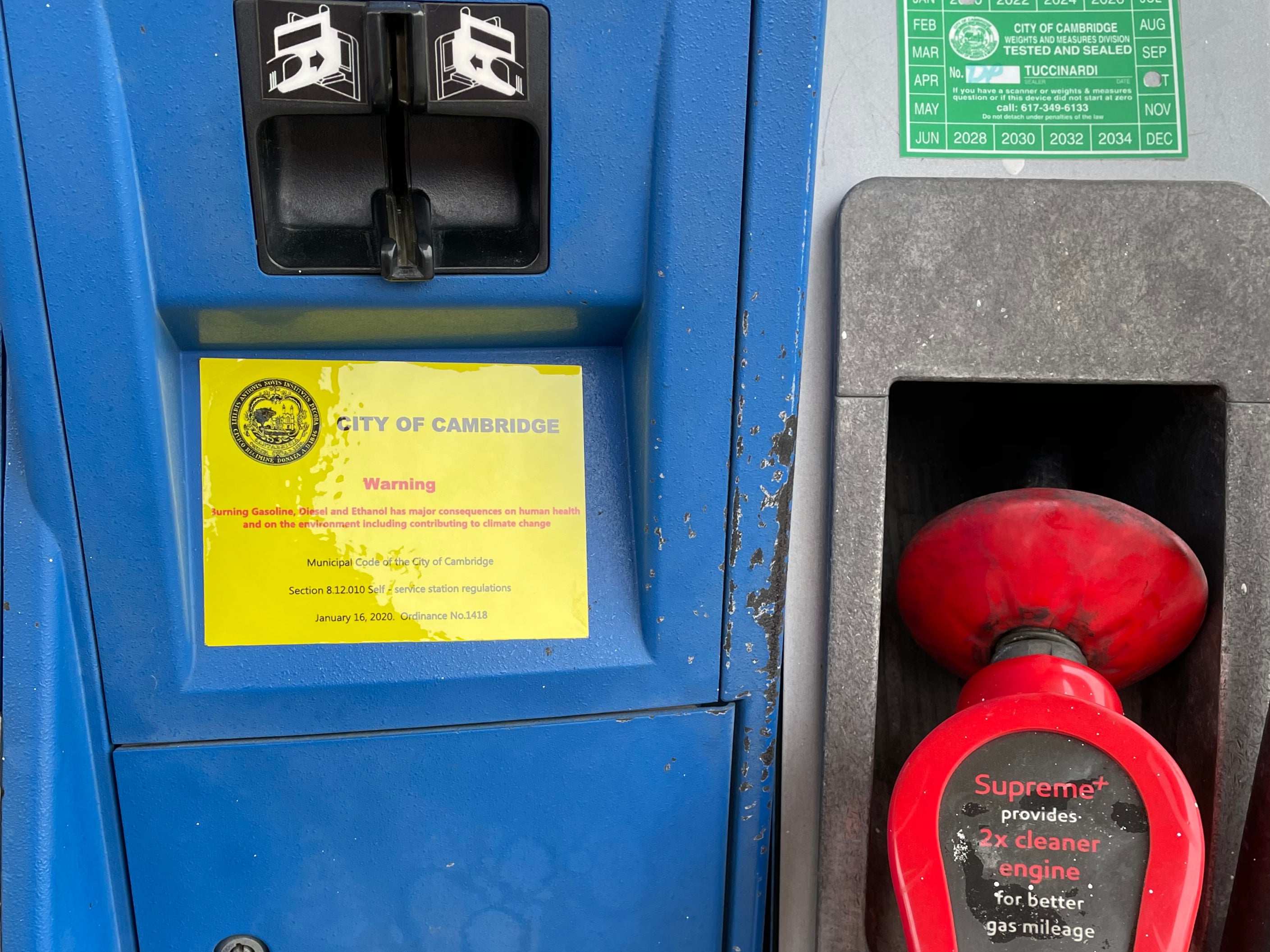 Warning labels on the climate crisis have been attached to gas pumps in Cambridge, Massachusetts