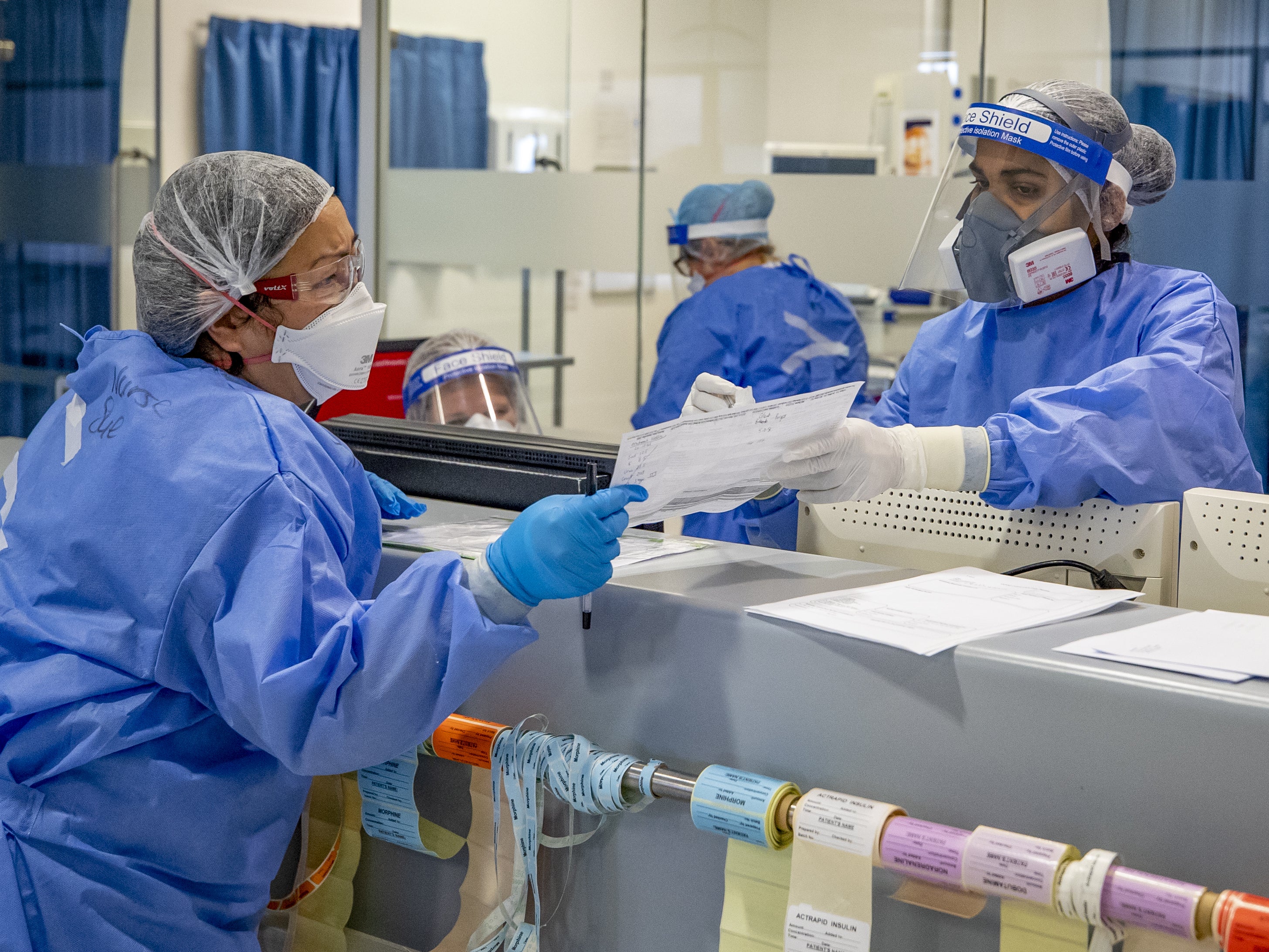 Health workers wearing full PPE on the intensive care unit at Whiston Hospital in Merseyside