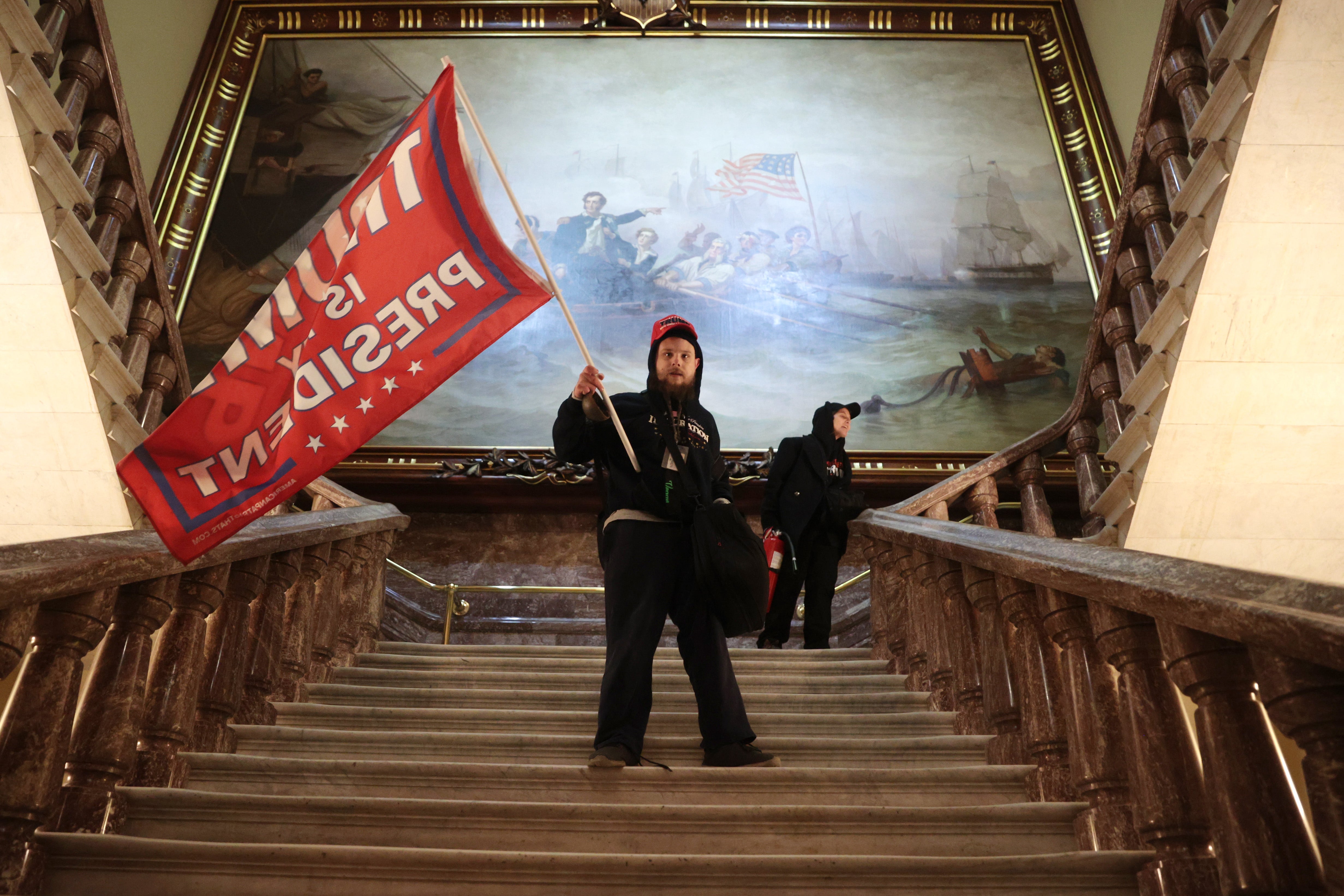 A protester holds a Trump flag inside the US Capitol Building near the Senate Chamber