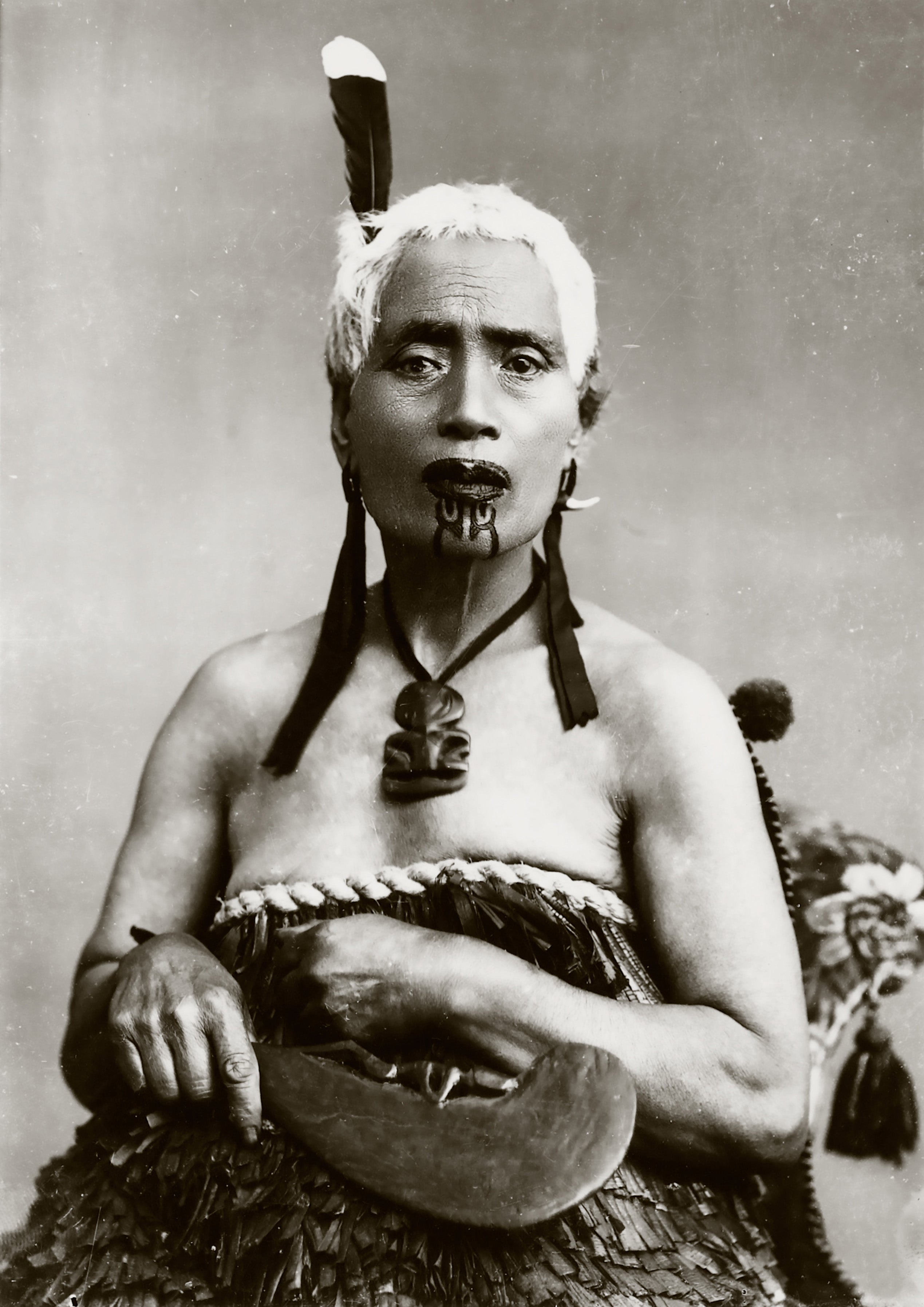 Portrait of a Māori woman with chin moko and feather from the prized huia bird, ca. 1900s. Māori women were traditionally tattooed on their chins and lips.