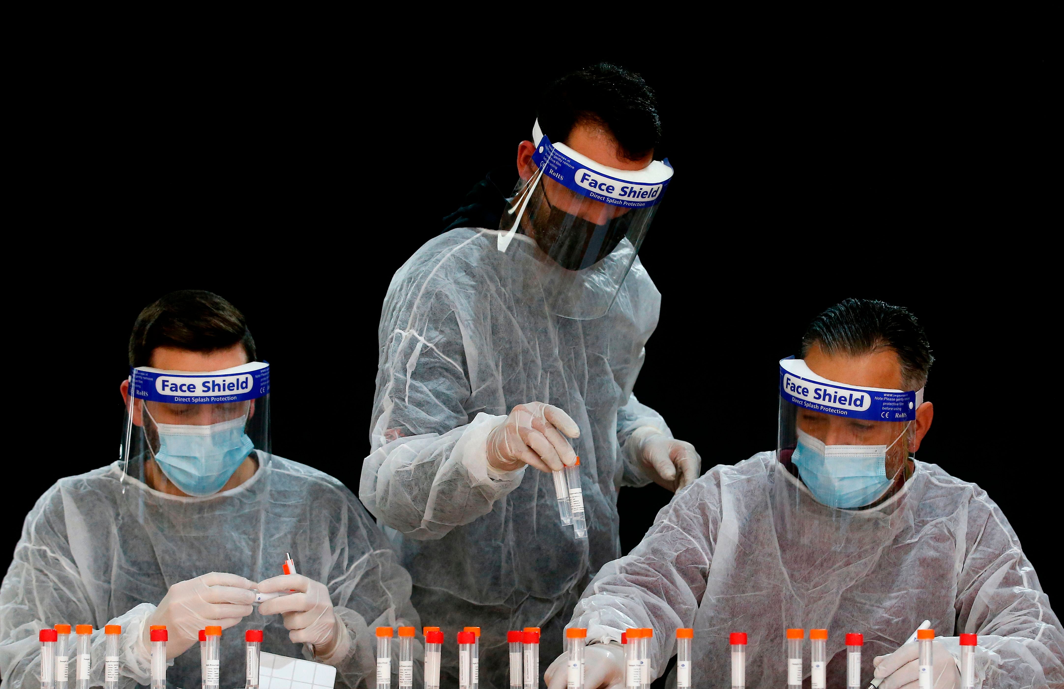 Palestinian health workers register samples for coronavirus testing in the West Bank village of Dura, southwest of Hebron, on January 8, 2021