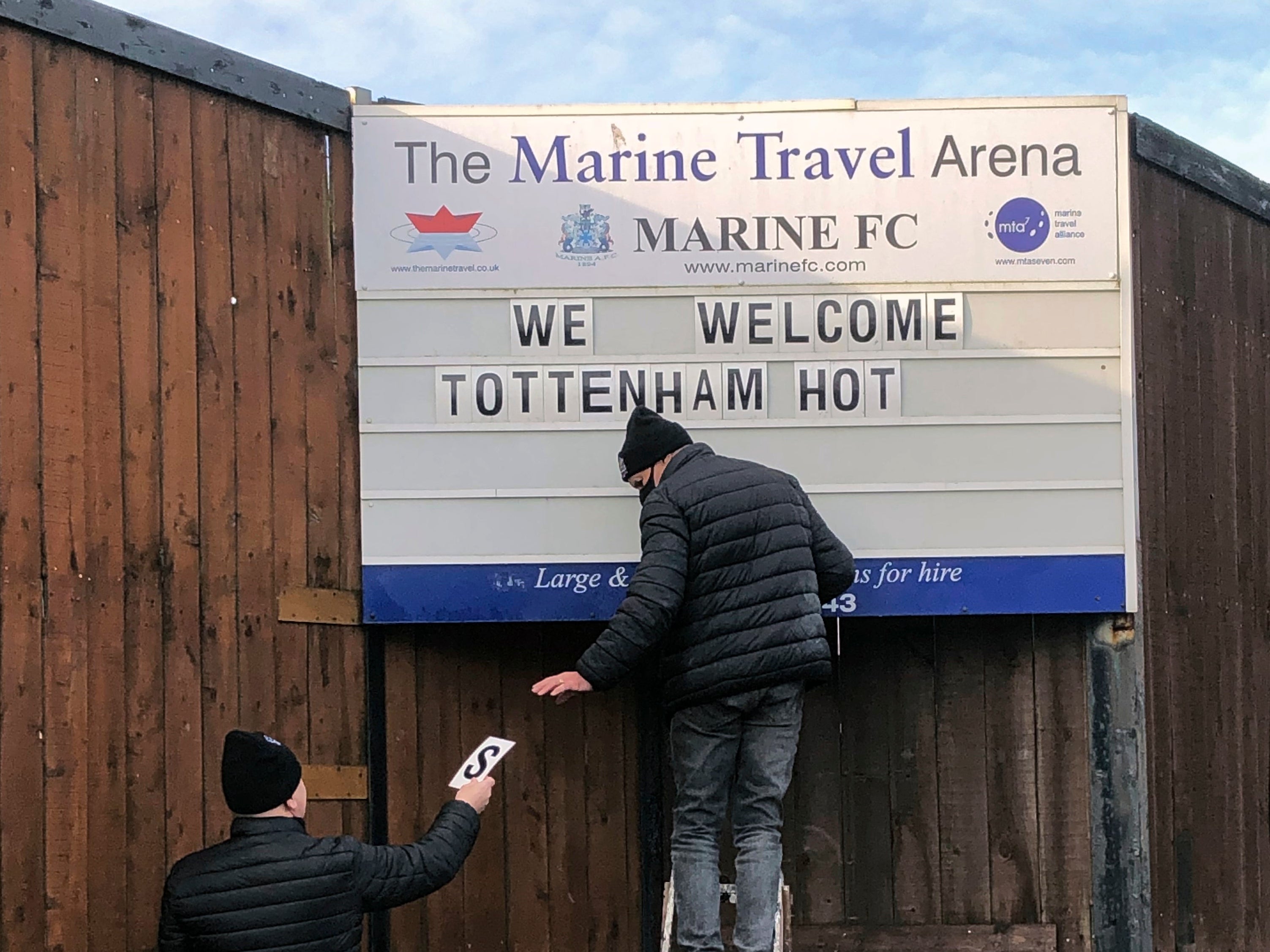 Volunteers hang up letters welcoming Tottenham Hotspur ahead of their FA Cup match