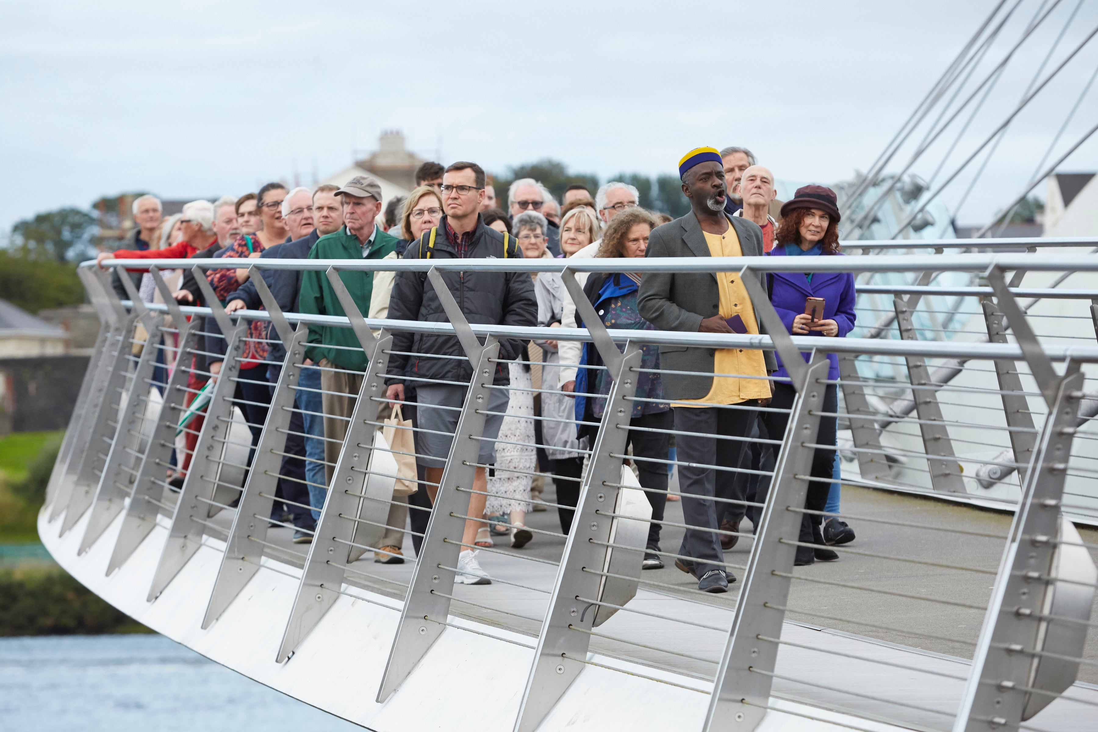 An audience is taken on a pre-performance walk across Derry’s Peace Bridge to the Guildhall