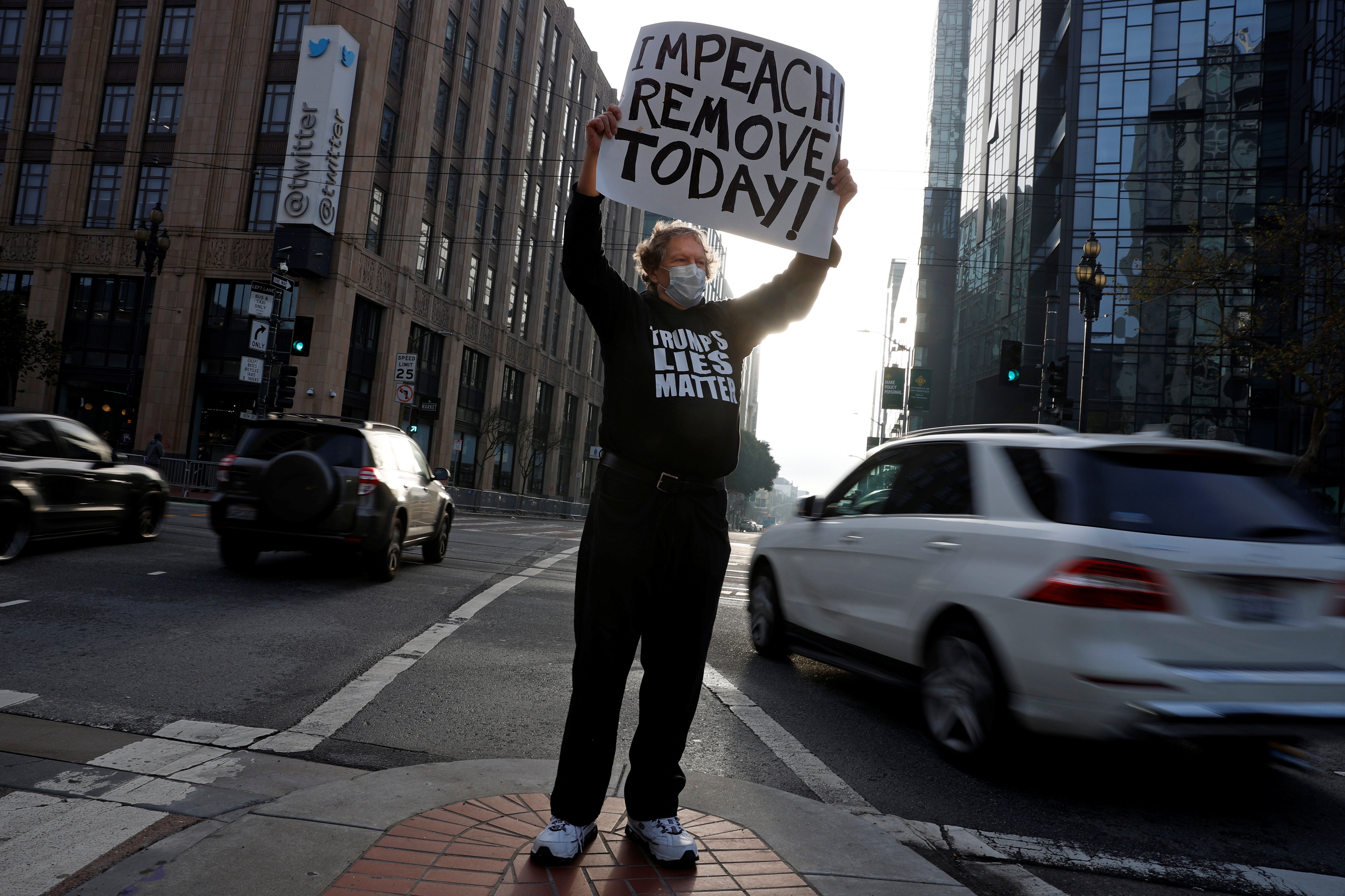 Kenneth Lundgreen holds a sign in counter-protest during what was supposed to be a pro-Trump demonstration outside Twitter headquarters in San Francisco