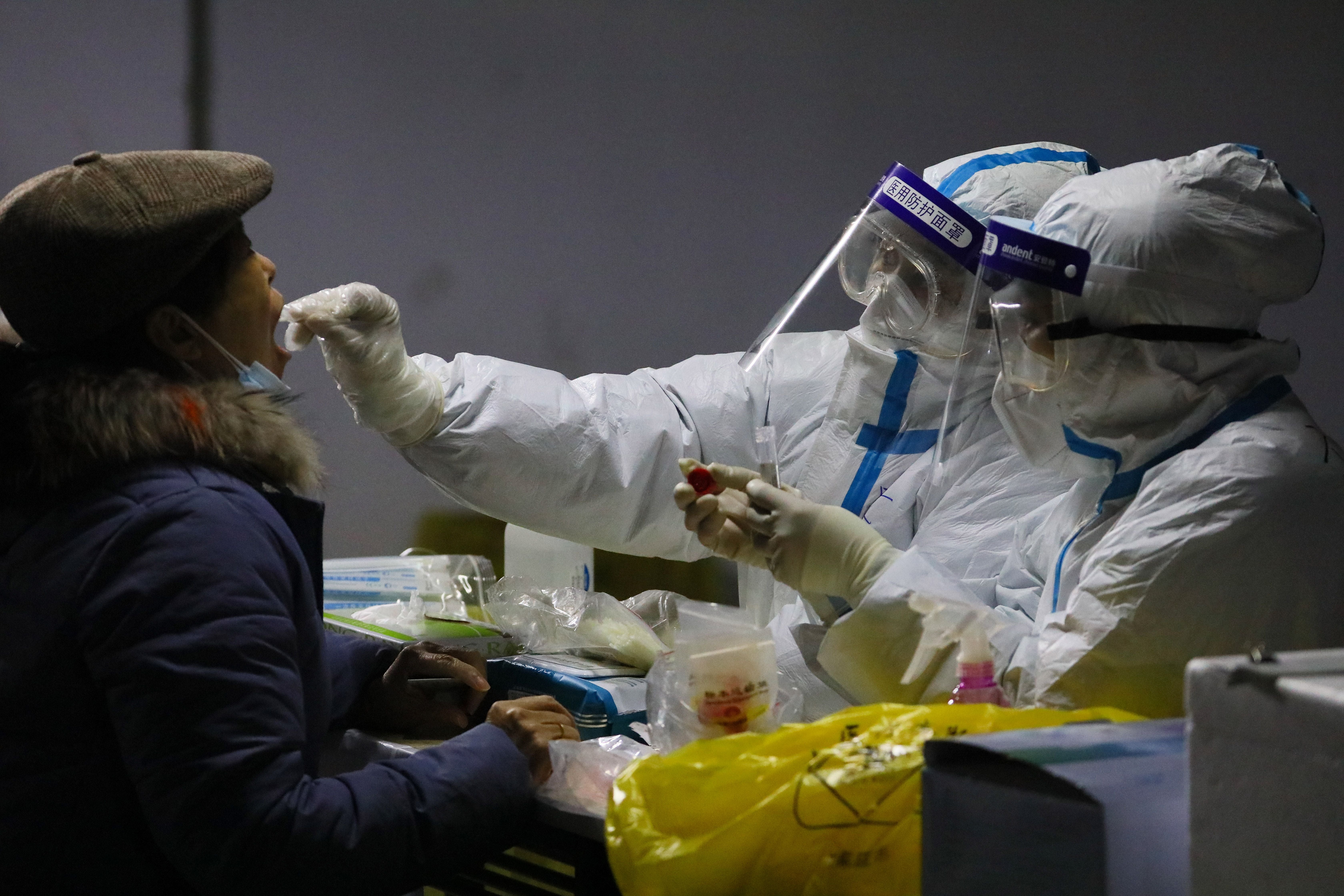 A resident undergoes a Covid-19 test in the basement of a residential compound as part of a mass testing programme following new cases of the virus emerging in Shijiazhuang, in central China’s Hebei province on 12 January 2021