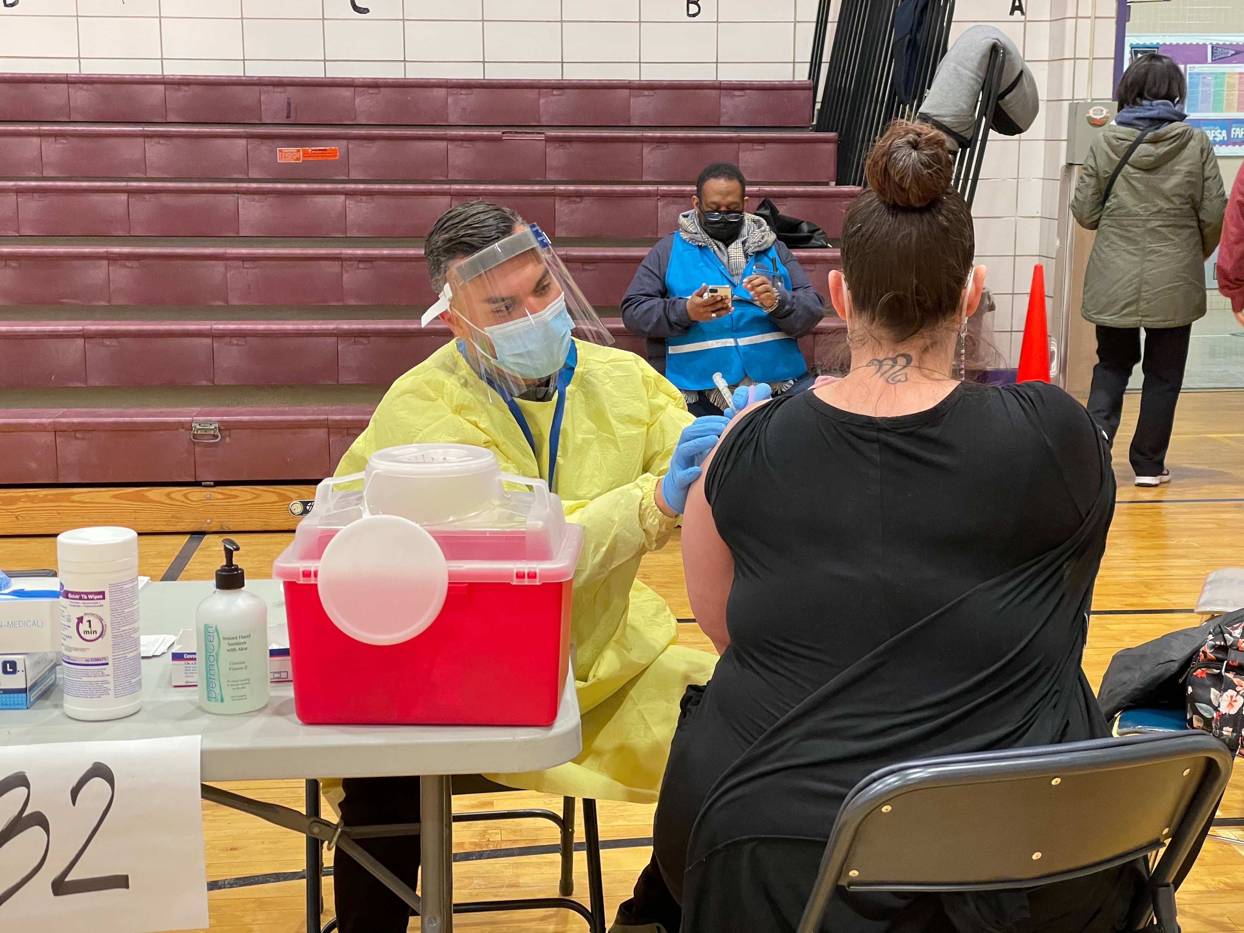 A New York teacher receives the first dose of Moderna’s Covid-19 vaccine on Tuesday, 13 January, at one of New York City’s new vaccination hubs