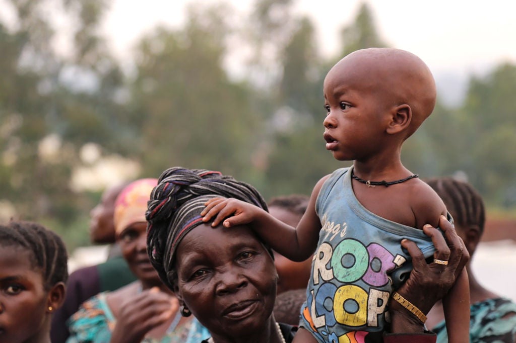 A woman holds a child on her shoulders in an Internally Displaced Persons Camp outside the town of Bunia, in Ituri province.