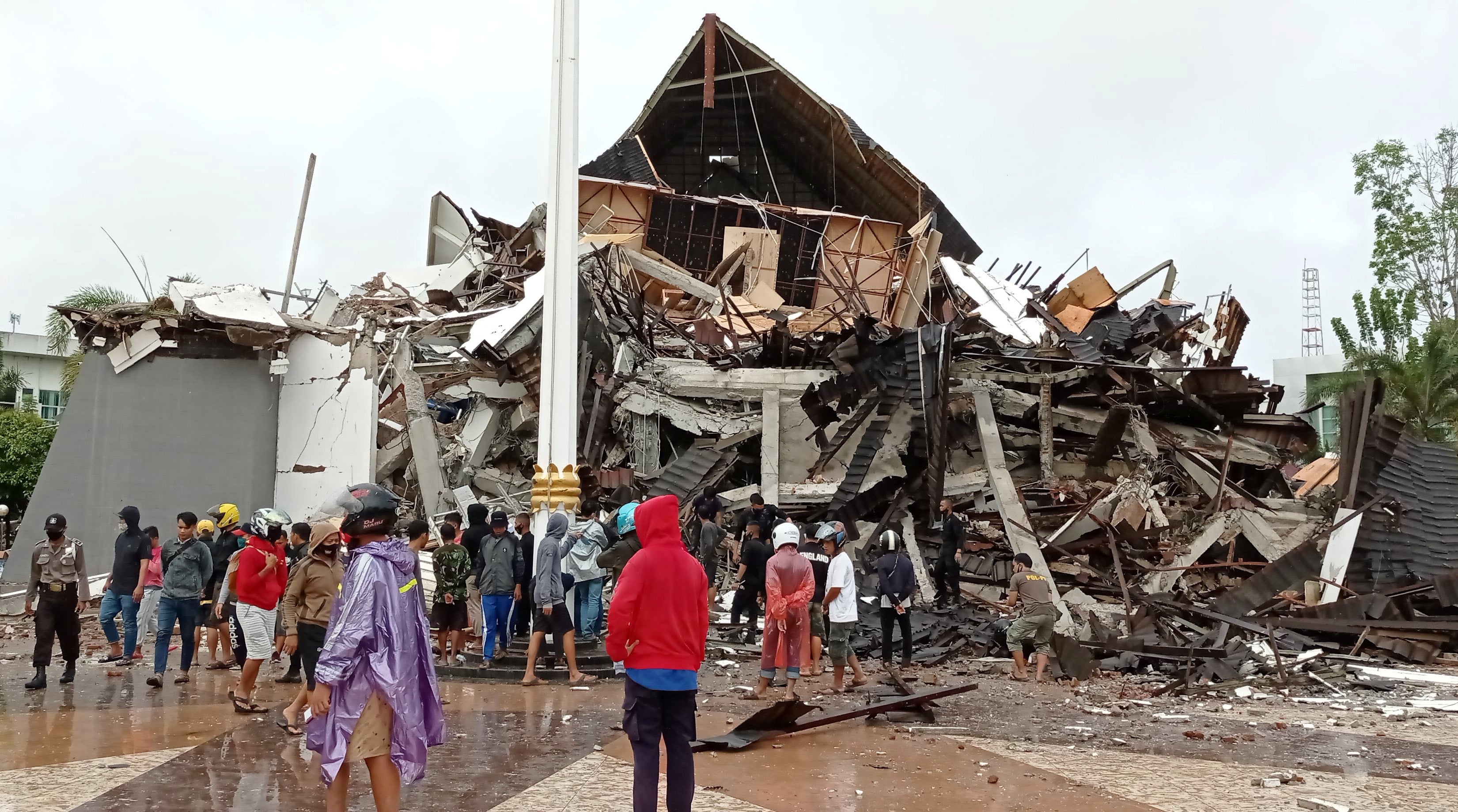 People look at the damaged province’s office of governor of West Sulawesi following an earthquake in Mamuju