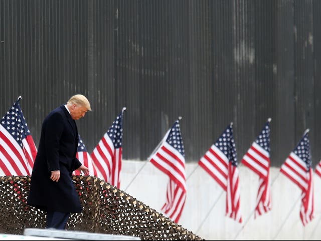 President Donald Trump walks down the steps before a speech near a section of the US Mexico border wall