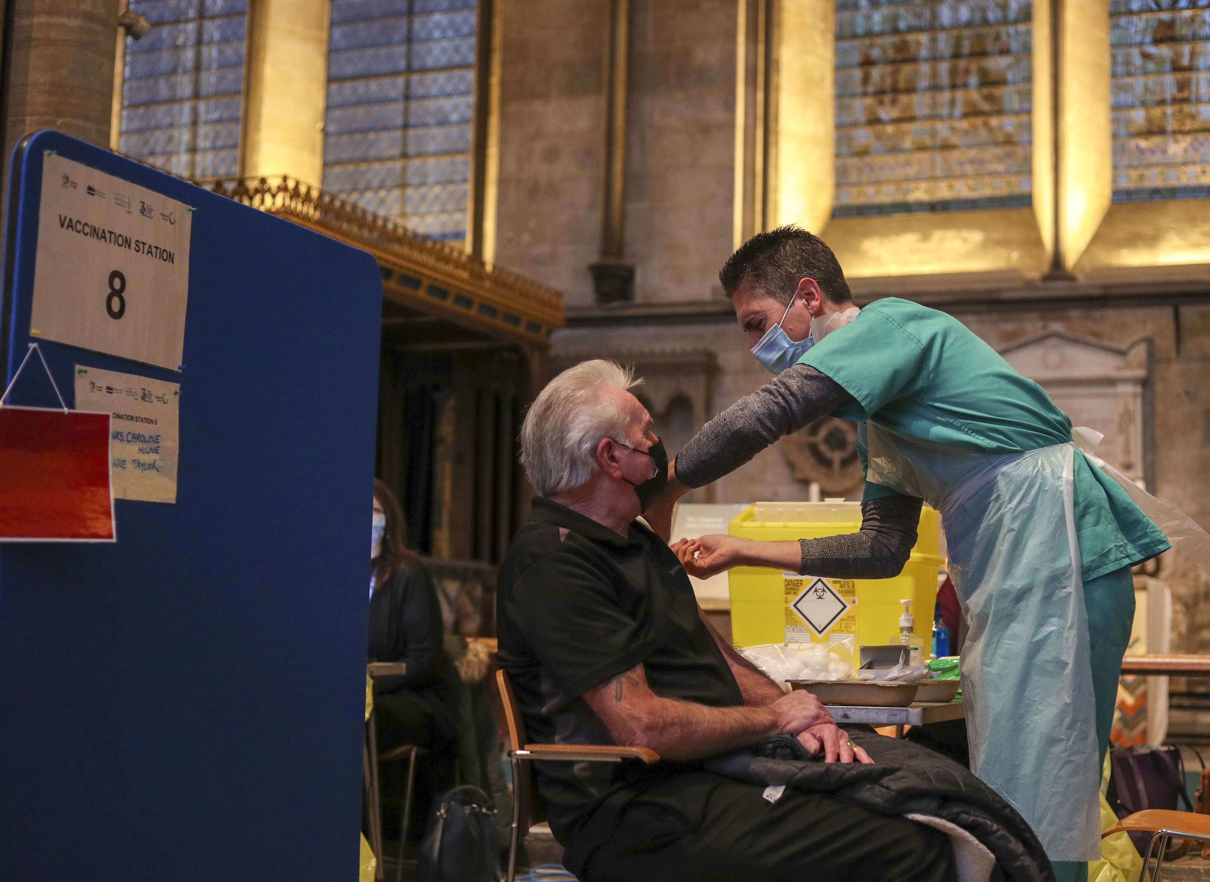 Lynn Court receives an injection of the Pfizer coronavirus vaccine from Dr Ben Kay at Salisbury Cathedral, Wiltshire.