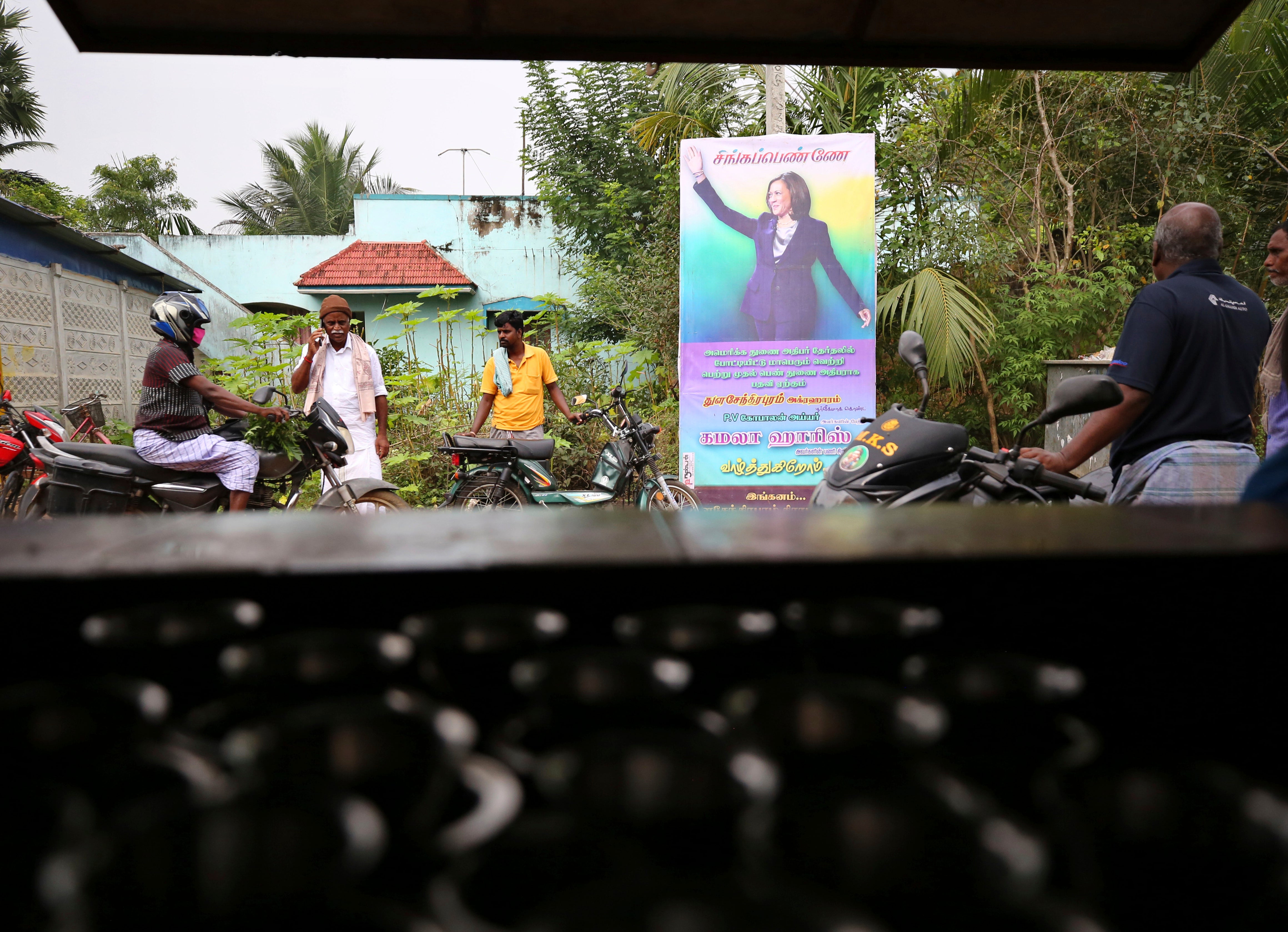 Indian villagers gather outside a local eatery next to a banner featuring US vice president-elect Kamala Harris with a message wishing her best, in Thulasendrapuram, the hometown of Harris' maternal grandfather, south of Chennai, Tamil Nadu state, India.&nbsp;