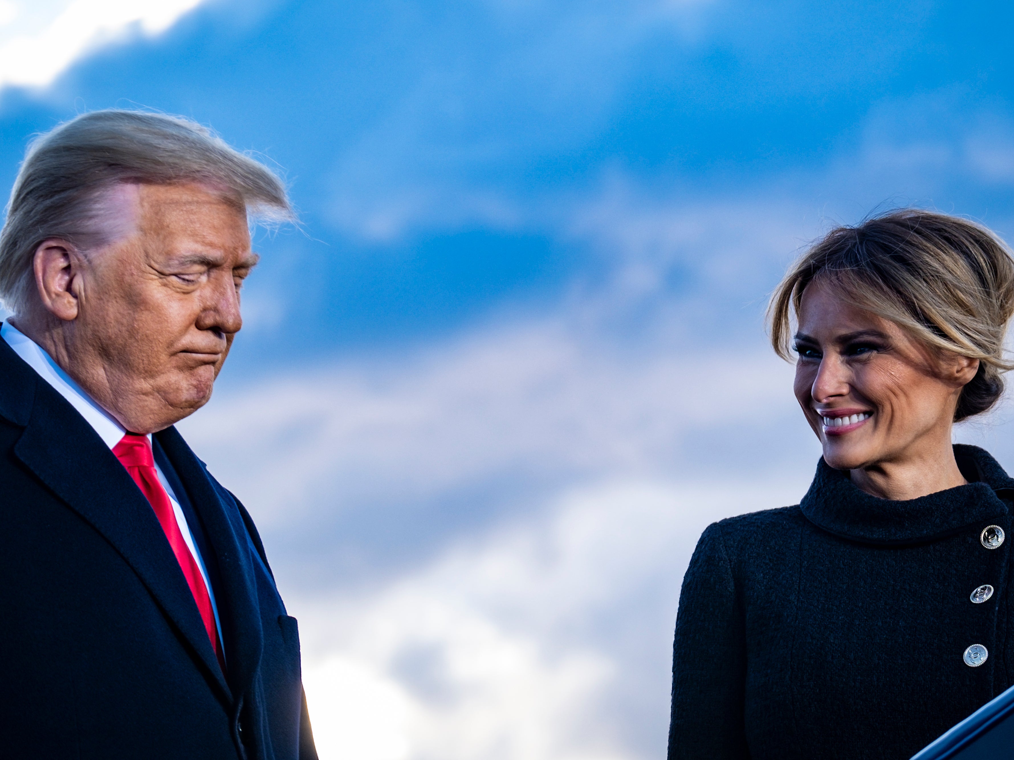 Donald Trump and Melania Trump pause while speaking to supporters at Joint Base Andrews before boarding Air Force One for his last time as President on 20 January 2021