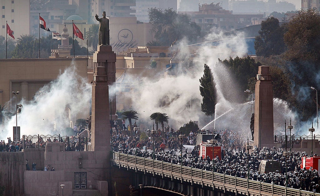 Riot police force protestors back across the Qasr El Nil bridge as they attempt to get into Tahrir Square on 28 January 2011 in downtown Cairo