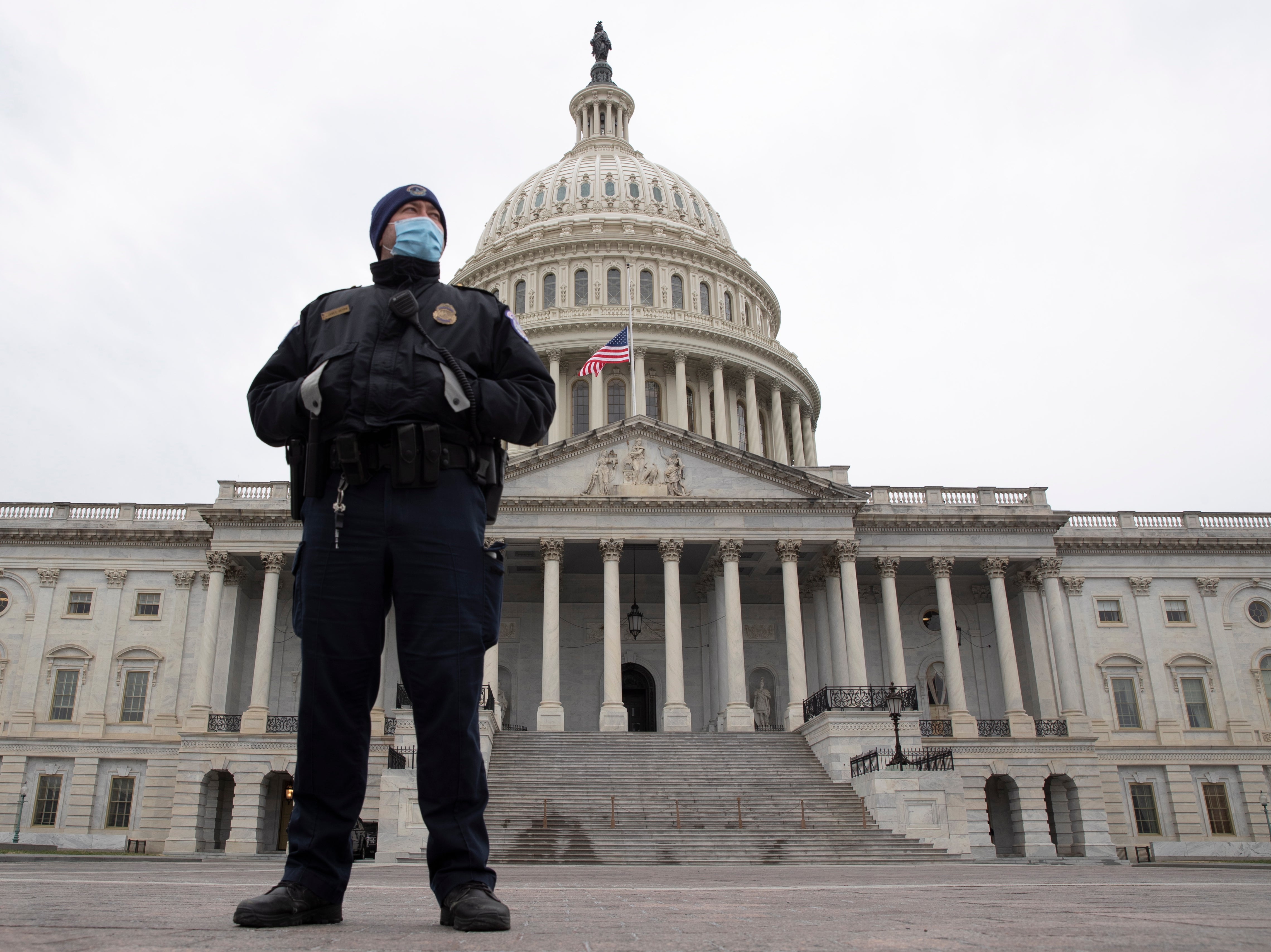 <p>A Capitol Police officer stands at the East Front of the US Capitol</p>