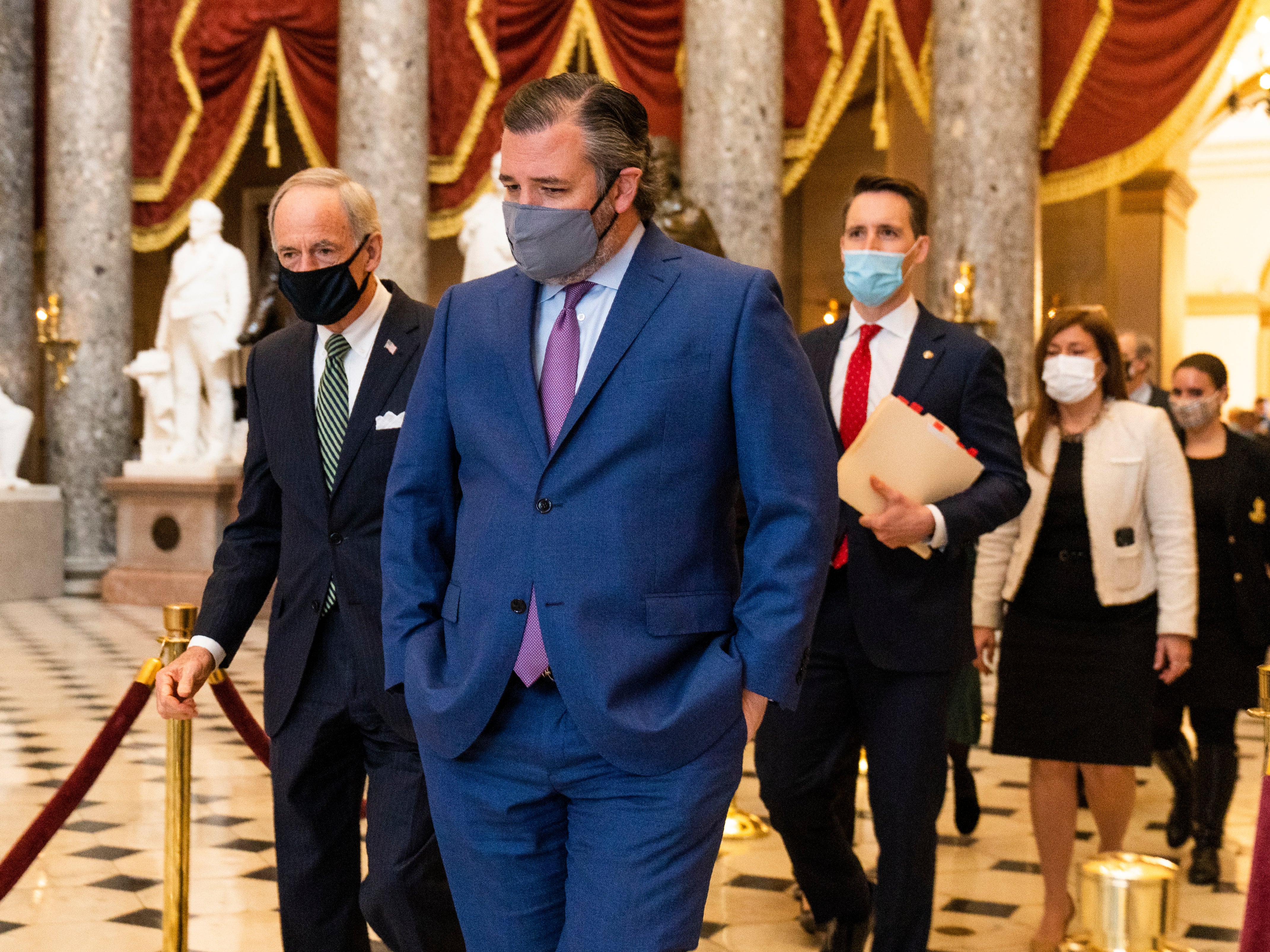 Ted Cruz, front, followed by Josh Hawley, walk from the House Chamber following a Senate procession carrying boxes holding Electoral College votes to the House Chamber for a joint session to confirm the Electoral College votes, on Wednesday 6 January 2021, in Washington