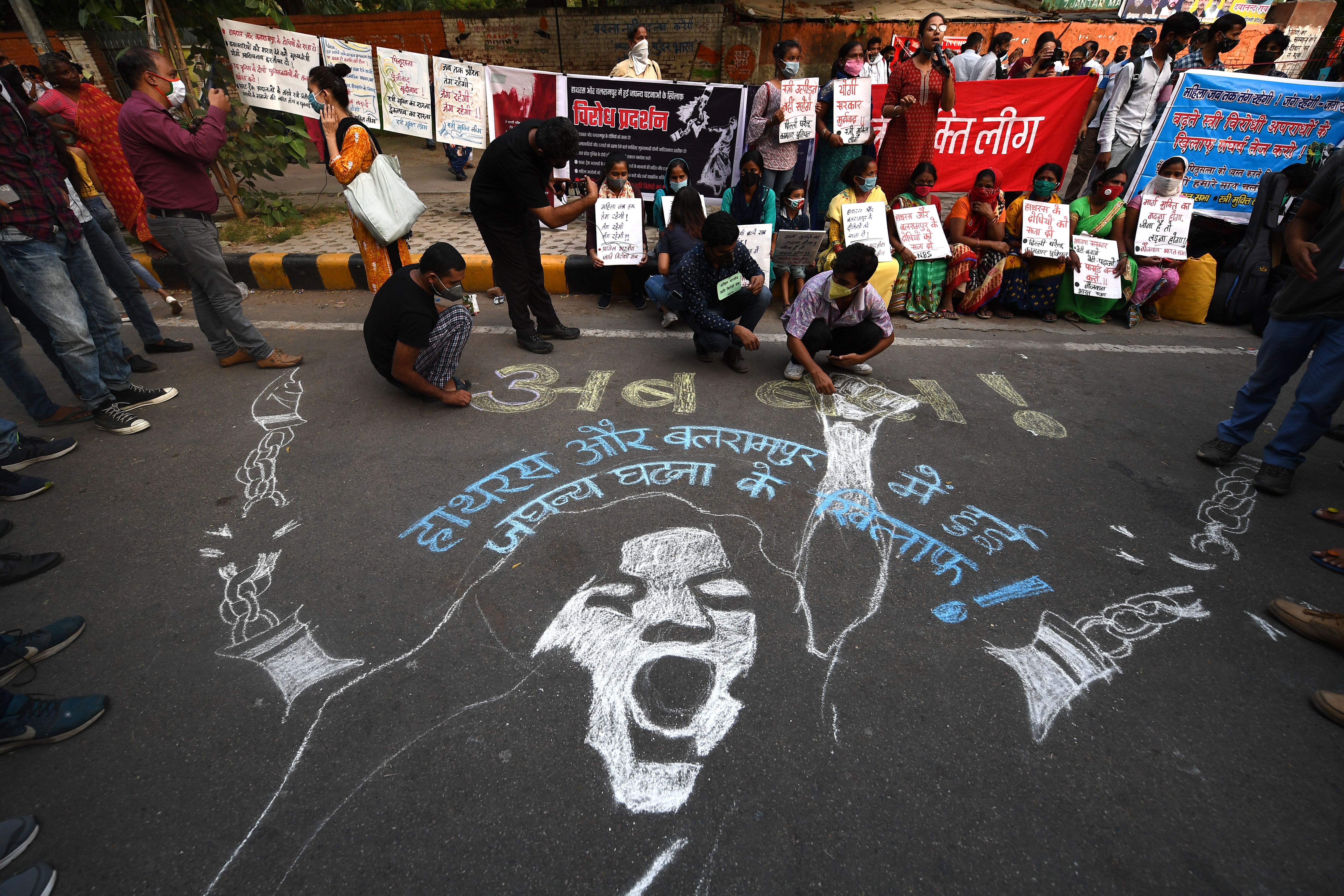 Demonstrators paint a floor mural as they protest against the alleged gang-rape and murder of a 19-year-old woman in Uttar Pradesh state