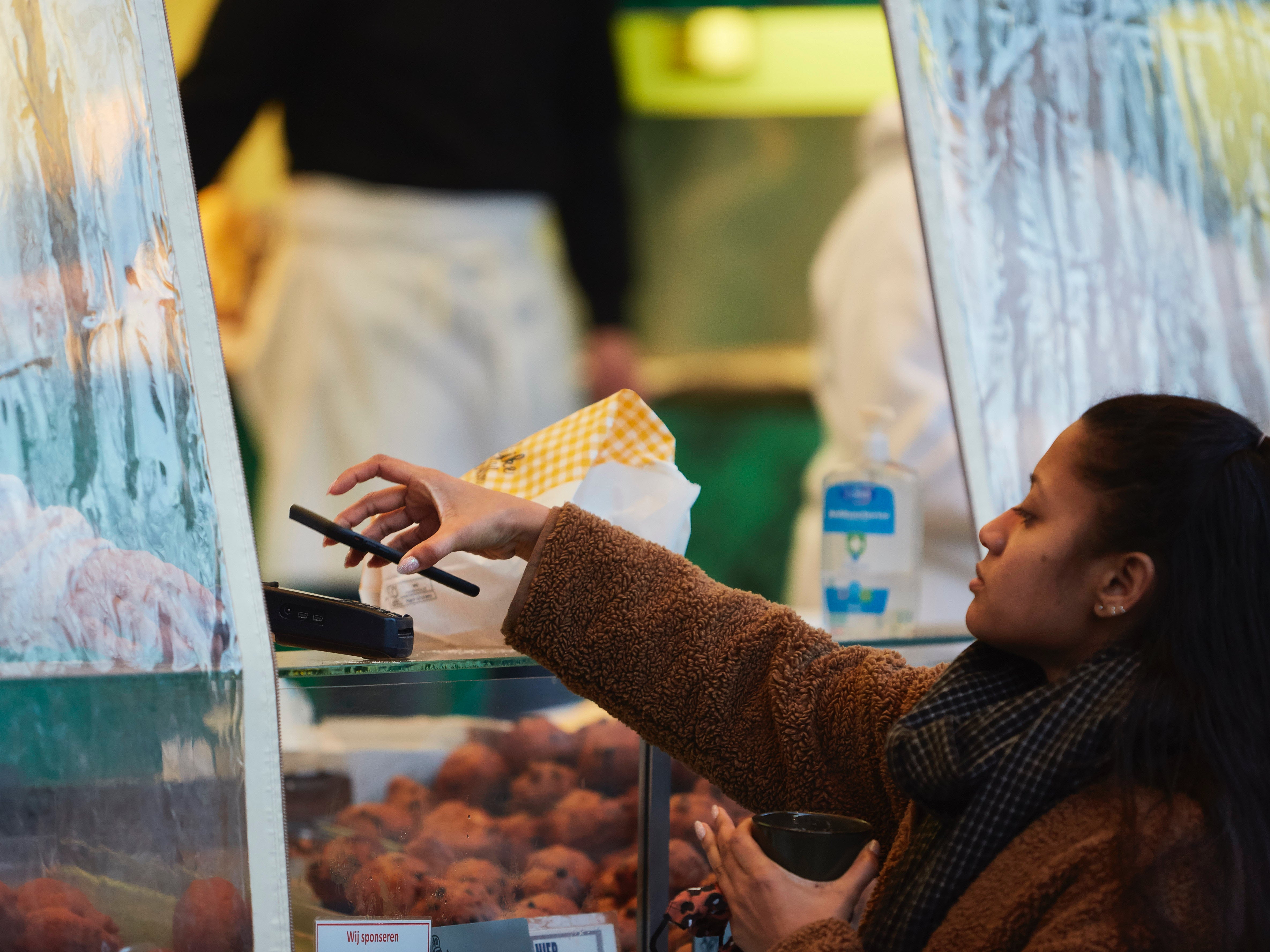 A customer makes a contactless payment with her smartphone&nbsp;