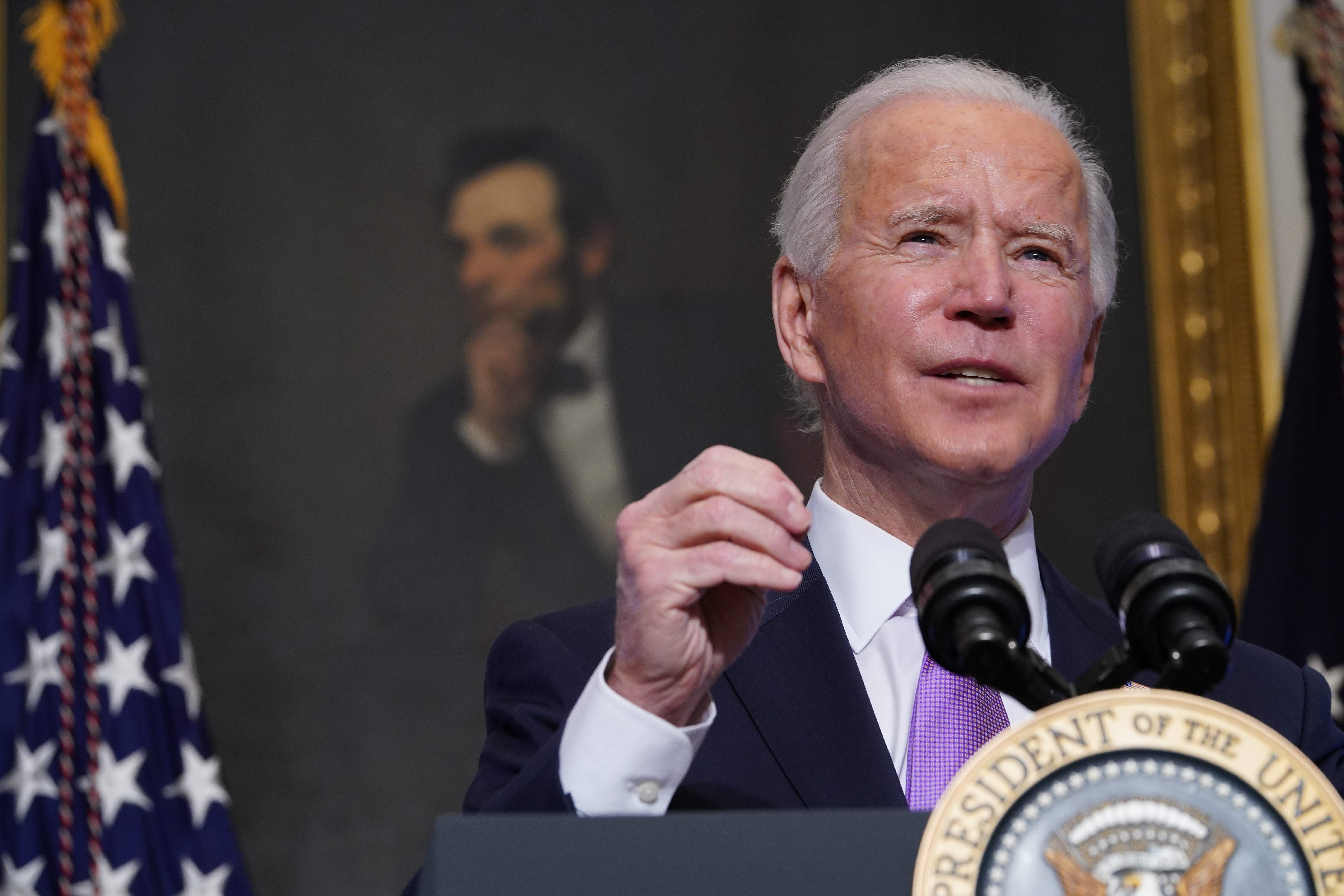 A painting of Abraham Lincoln is seen as US President Joe Biden speaks on Covid-19 response in the State Dining Room of the White House in Washington, DC