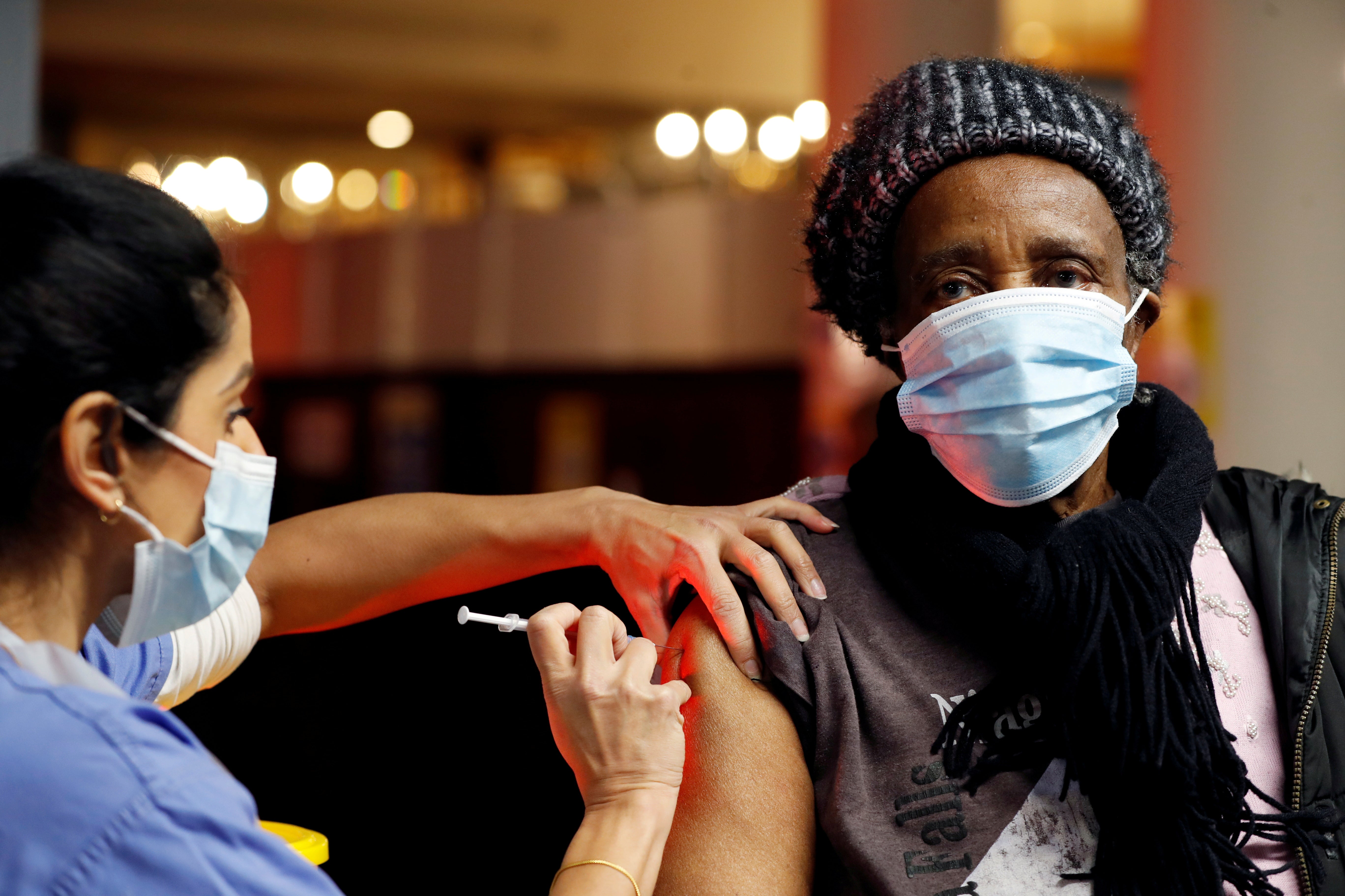 A health worker administers an injection of a COVID-19 vaccine at an NHS centre in a closed nightclub