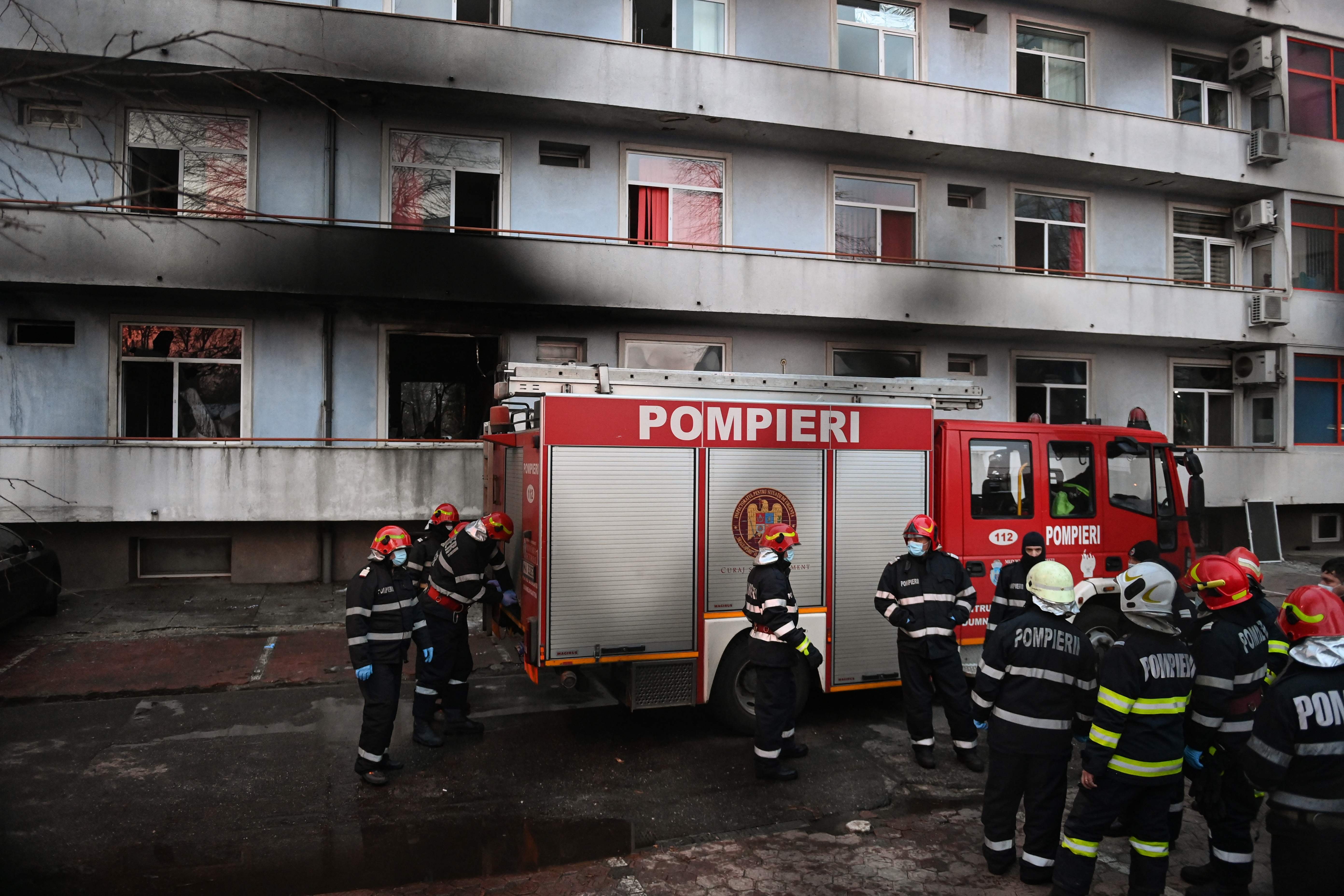 Firemen gather in the courtyard of the Matei Bals infectious diseases hospital's &nbsp;burned pavilion in Bucharest on January 29, 2021 where at least four people died after a fire broke out in Romania's main hospital treating Covid-19 patients.