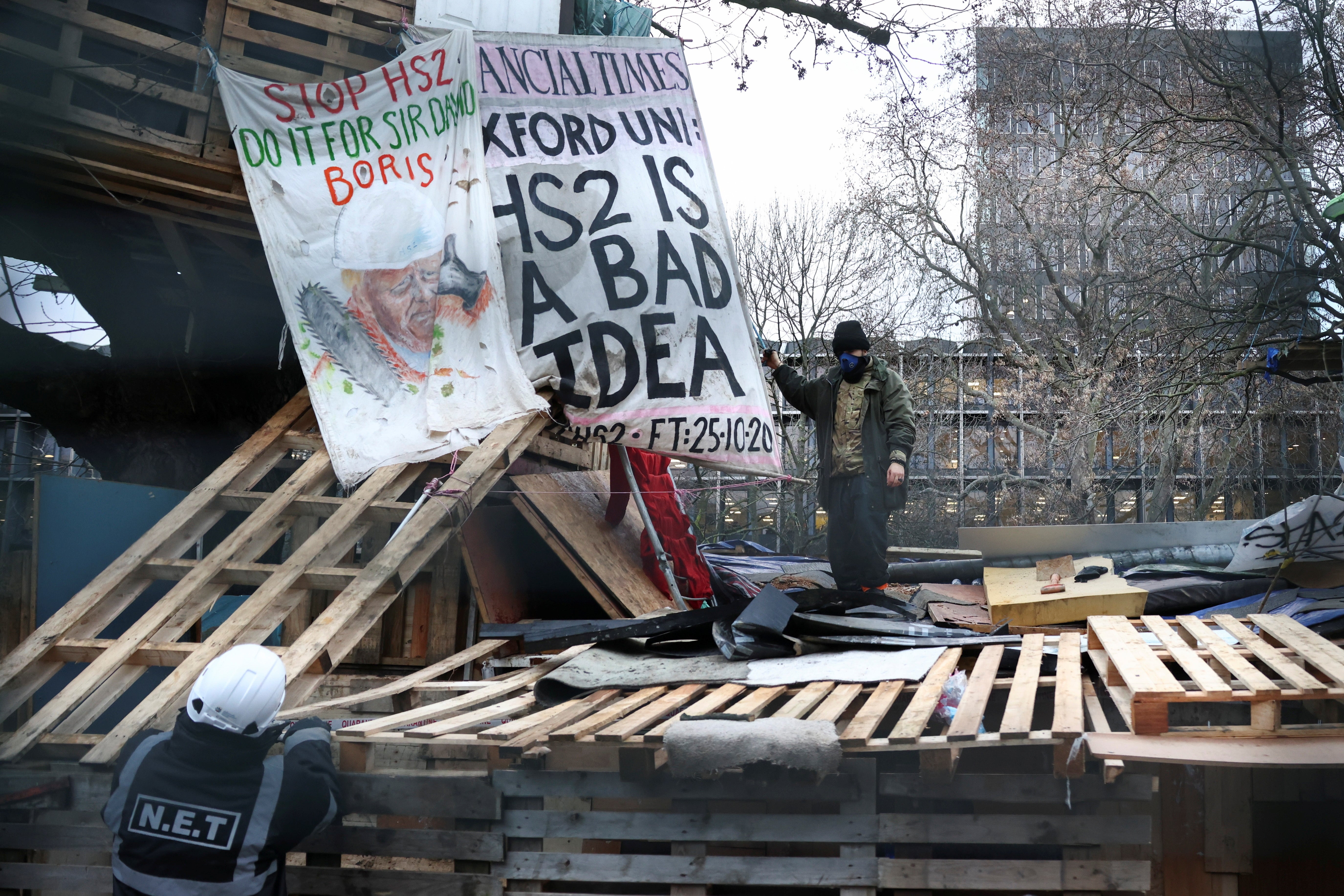 A member of the eviction team speaks to an Extinction Rebellion activists who stands in a makeshift camp at Euston Station to protest against the HS2 high-speed railway