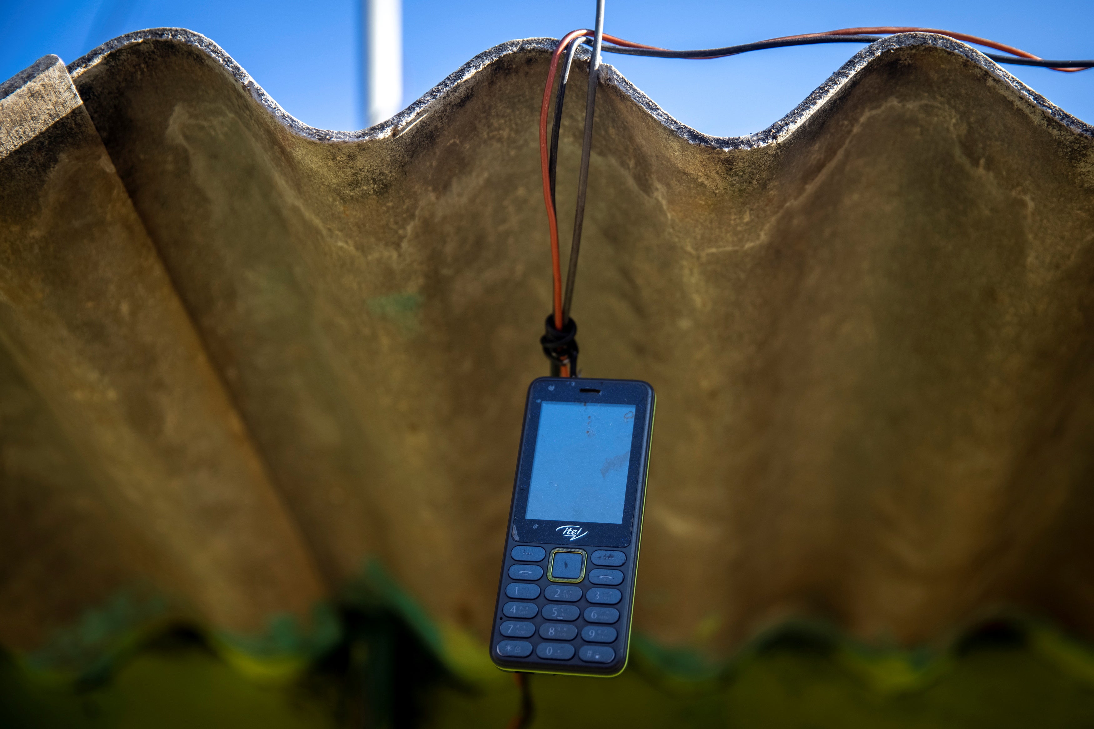 A phone belonging to Reena Jani is hung up outside her home to receive signal, in Pendajam village in Koraput