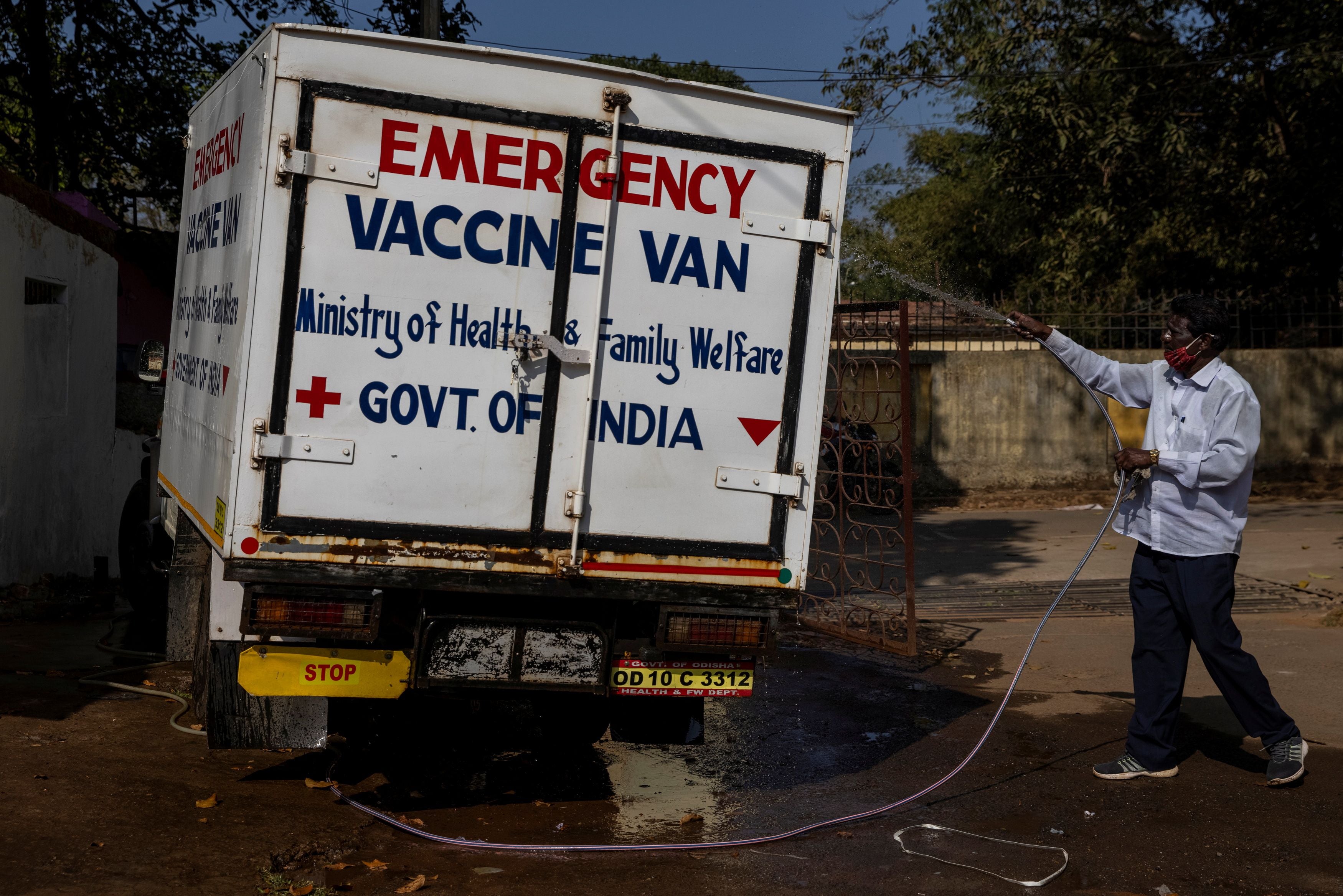 A health department driver washes a vaccine van before transporting the vaccine