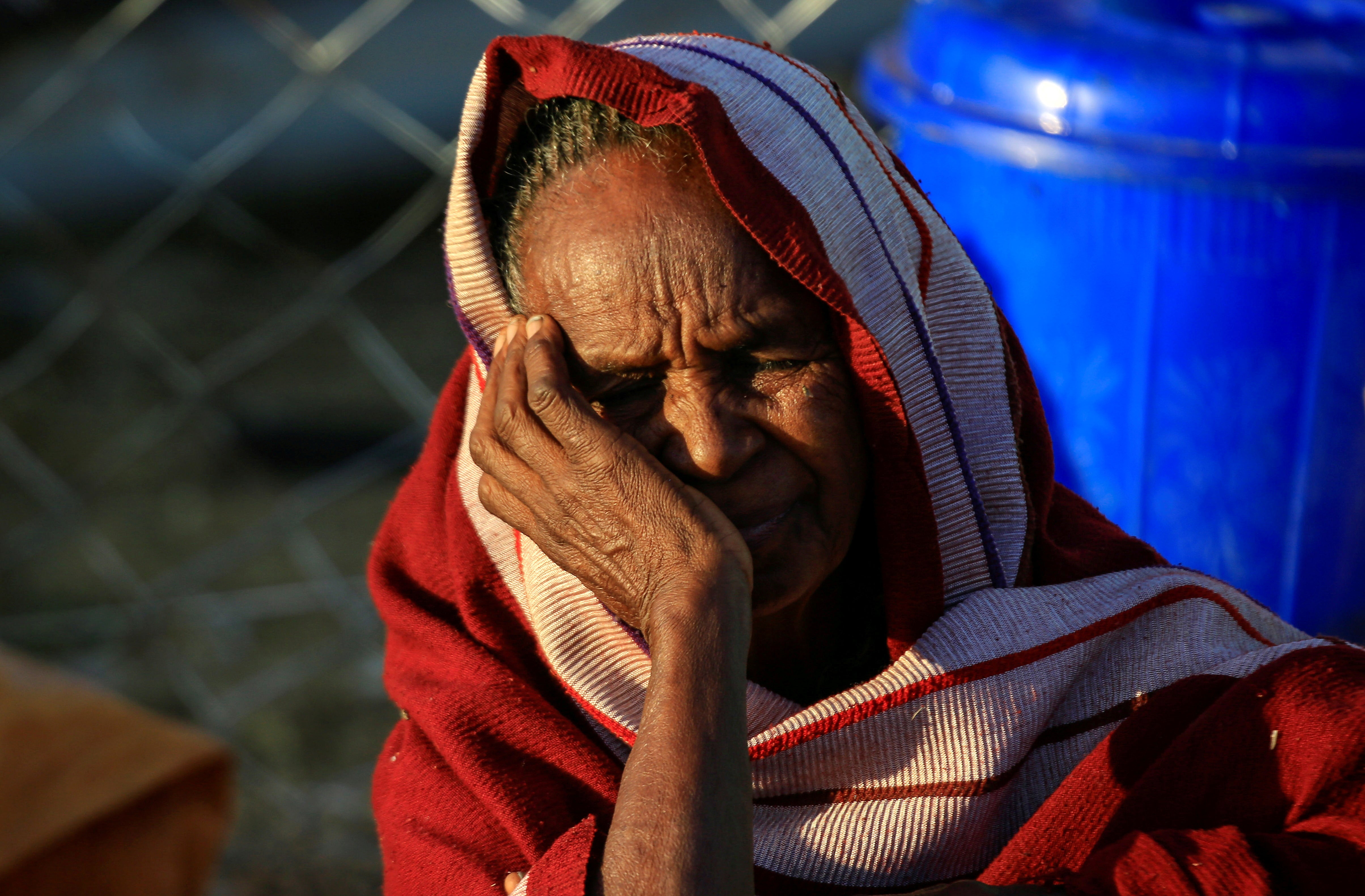 An Ethiopian woman, who fled the ongoing fighting in Tigray region, is seen at dawn within Hamdayet village on the Sudan-Ethiopia border, in the eastern Kassala state