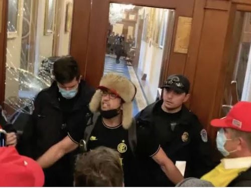 Zachary Alam, here pictured in fuzzy headgear, was pardoned by President Donald Trump for crimes committed during the Capitol riot, but has since been arrested and charged with breaking into a Virginia home and stealing from its residents