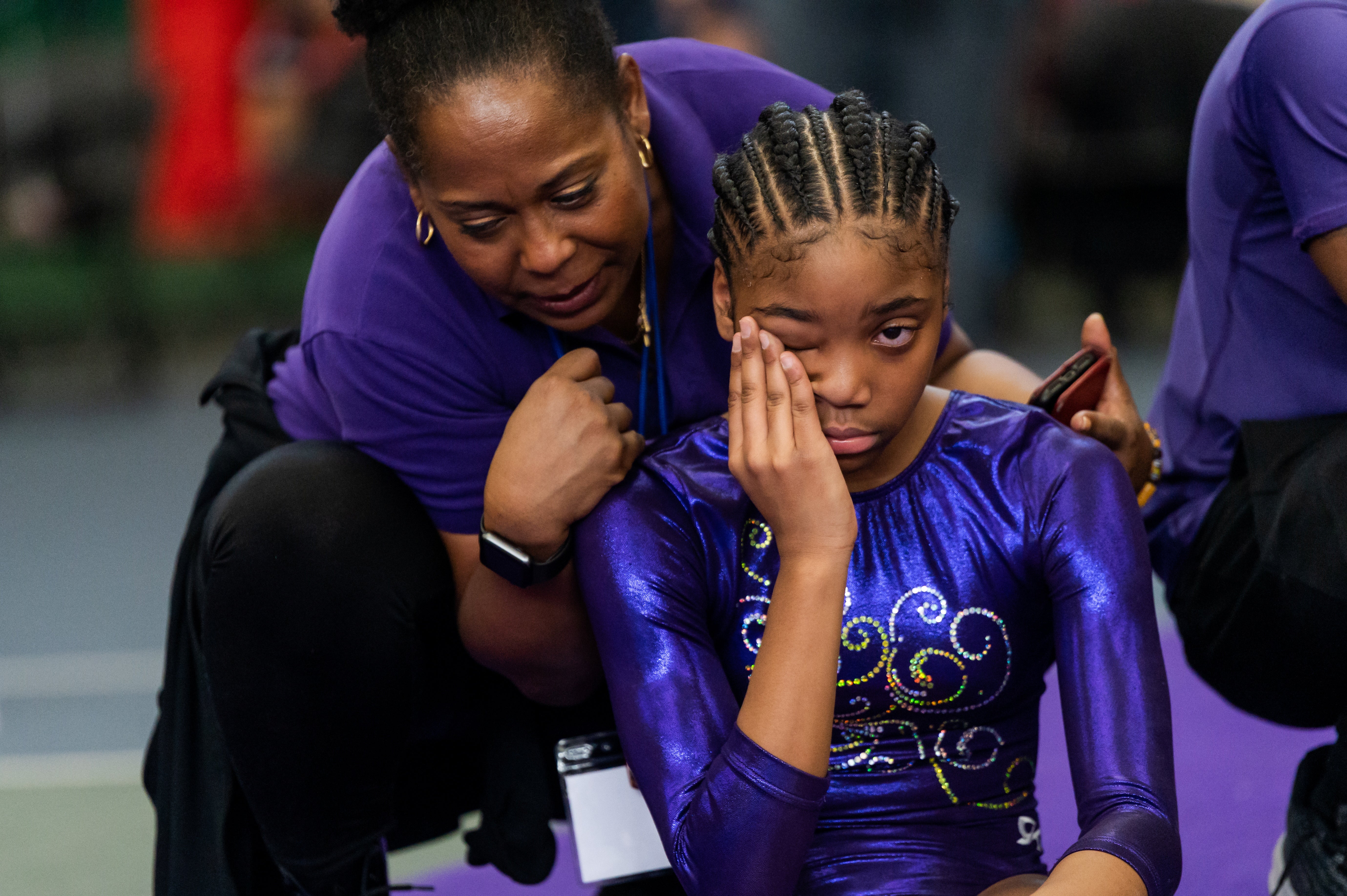 Hilliard consoles gymnast Chelsea Taylor Moore during a competition