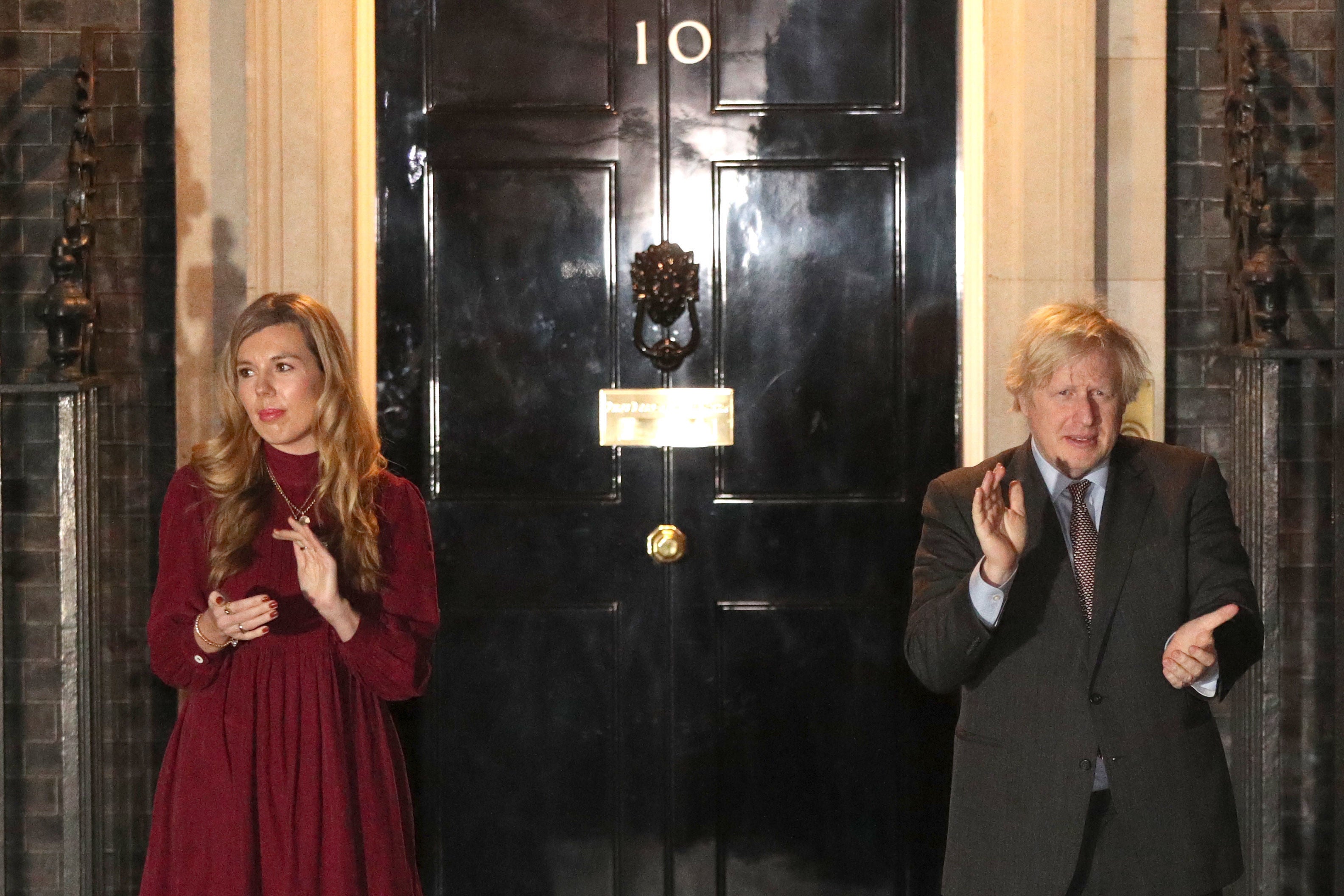 Prime Minister Boris Johnson and his partner Carrie Symonds outside 10 Downing Street, London, join in with a nationwide clap in honour of Captain Sir Tom Moore