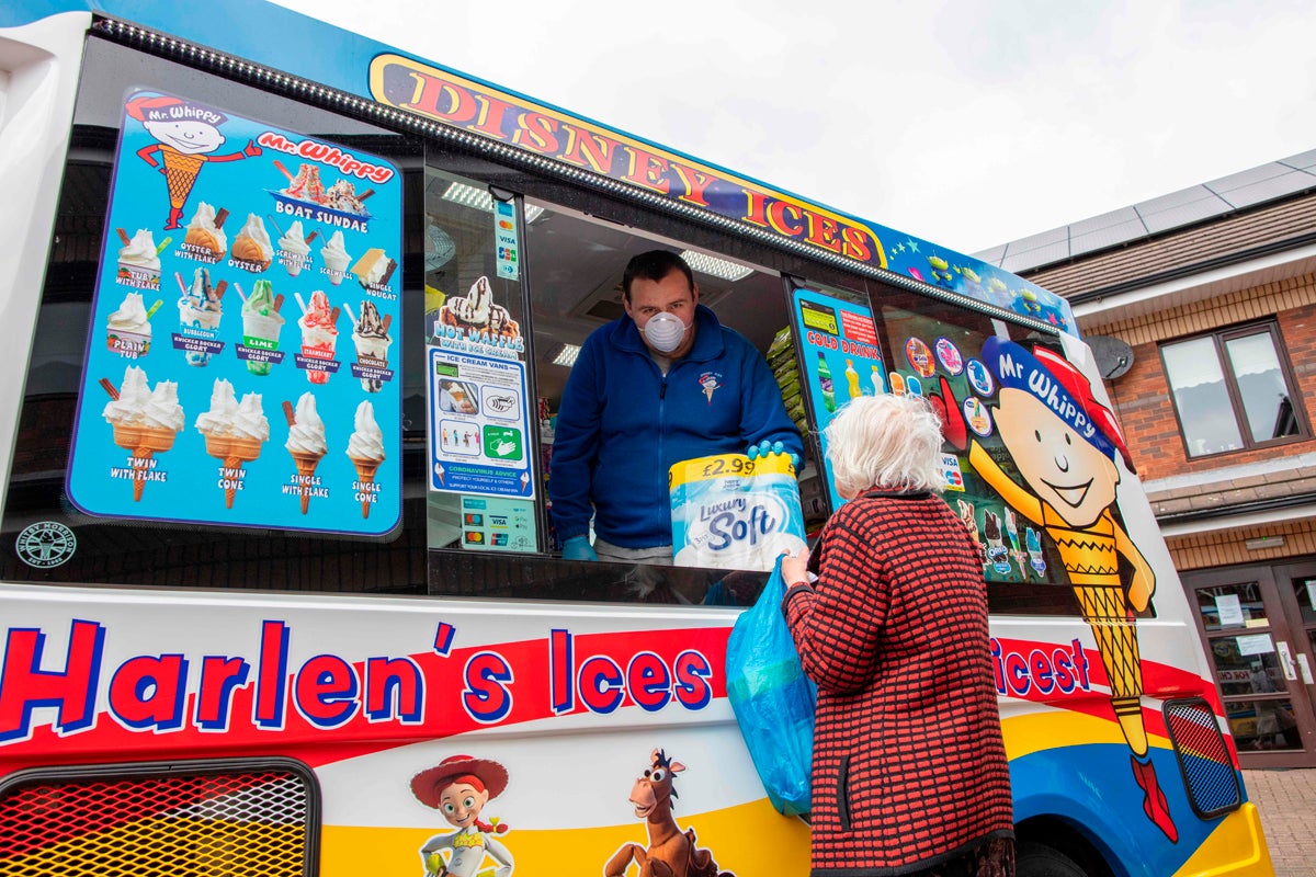 Workers who turned their van into a mobile mini-market sell food and household items to local residents at a supported housing estate in west Belfast