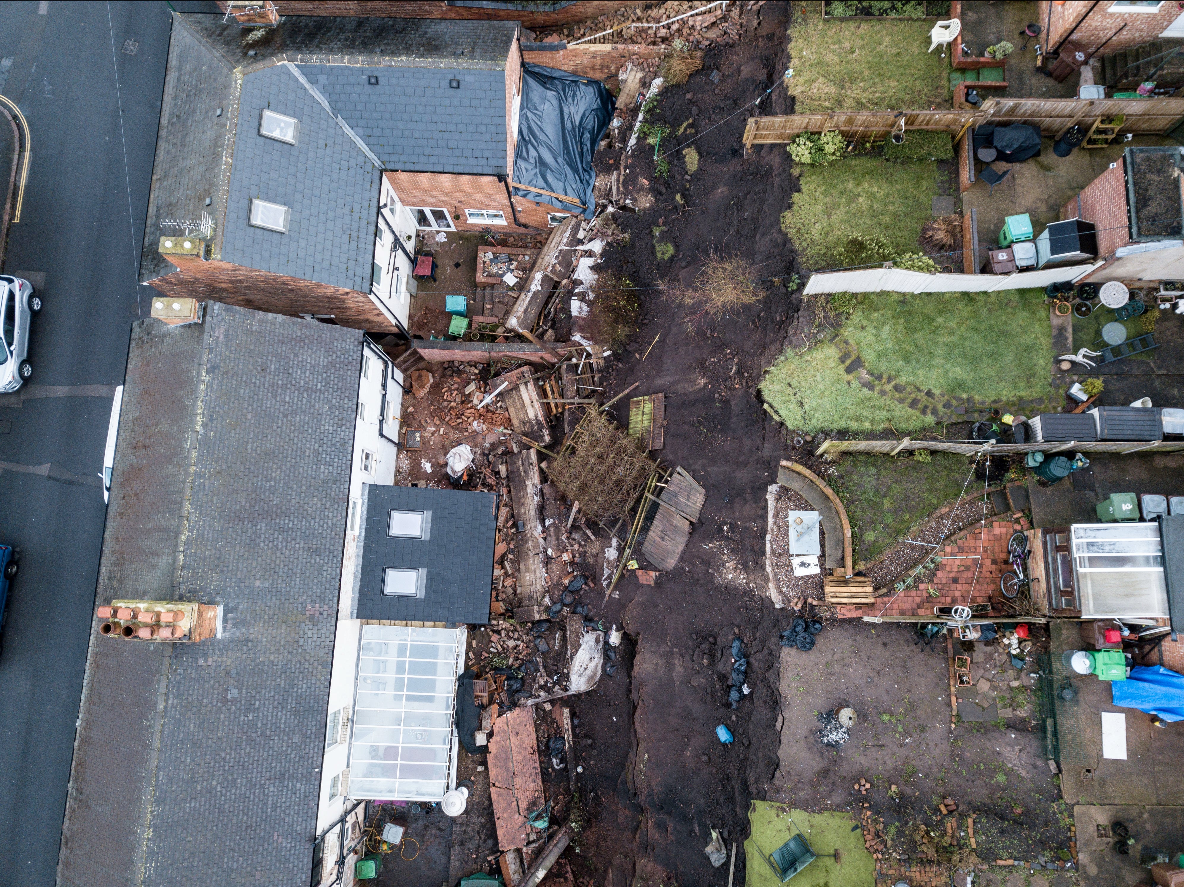 Five families were evacuated from their homes in the middle of the night after a “landslide” caused a 70ft wall to collapse into their properties