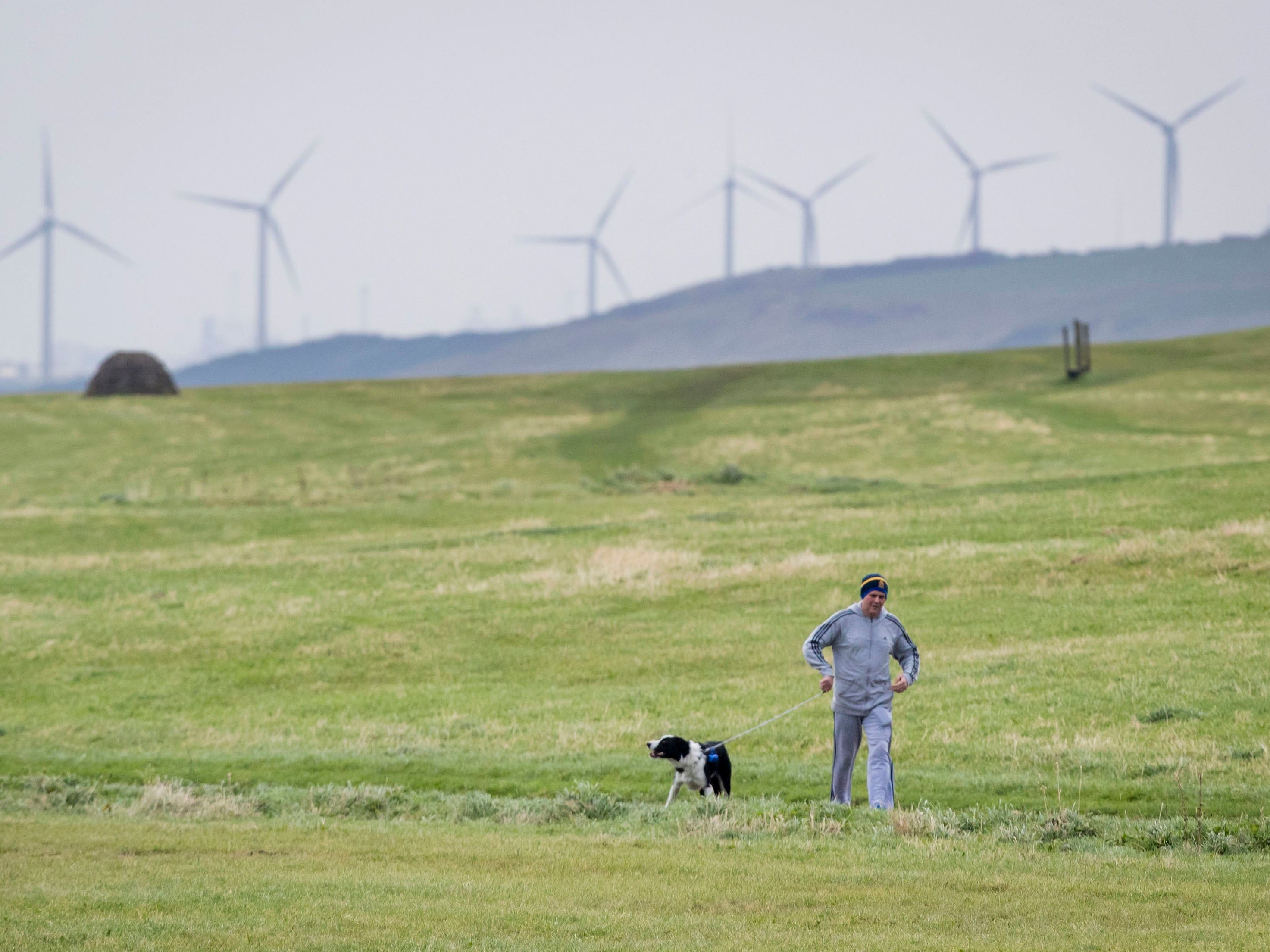 Going back in time. A man walks his dog in Whitehaven, Cumbria, near the site of the proposed coal mine