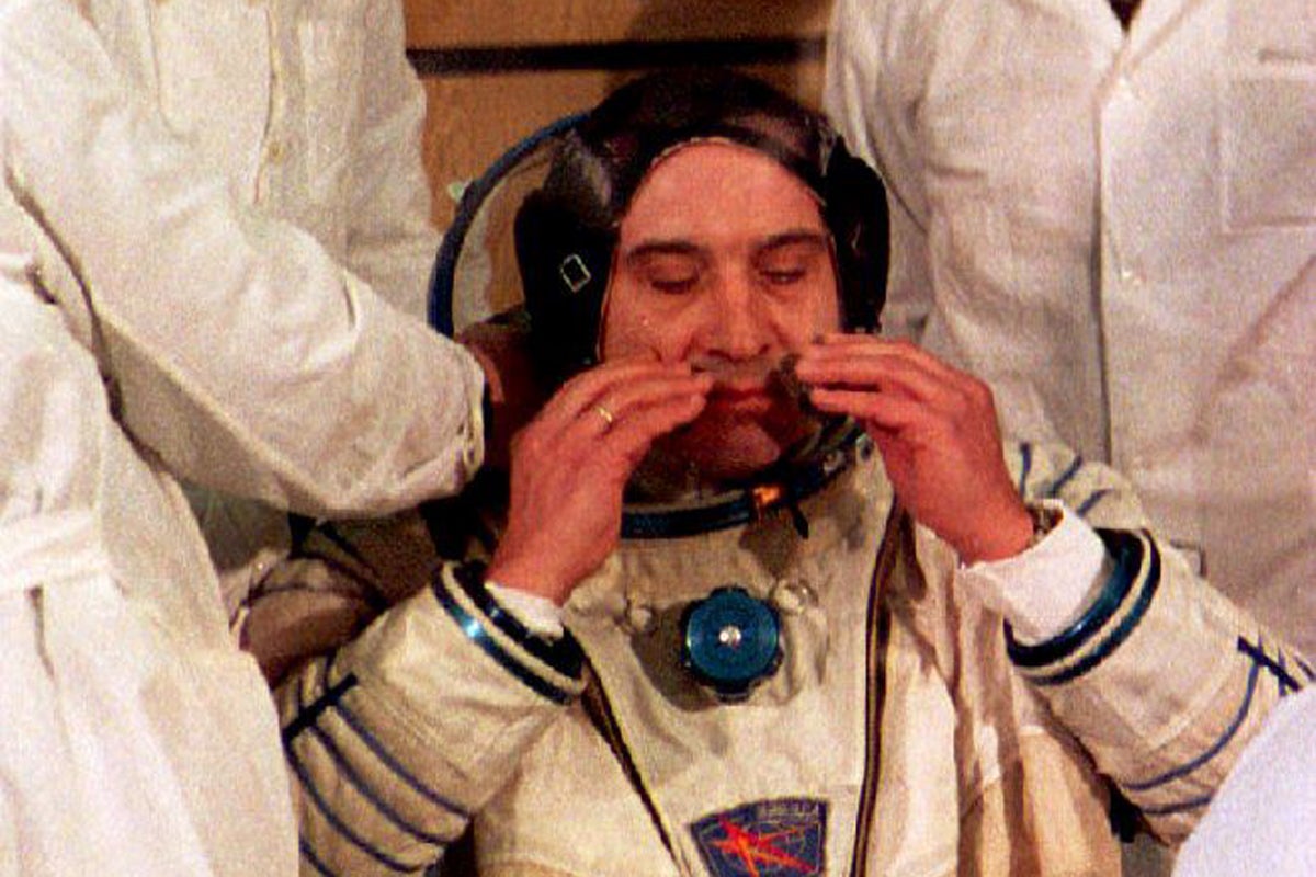 Technicians help Russian cosmonaut Valeri Polyakov don his helmet before his 1994 mission, which became the longest undertaken