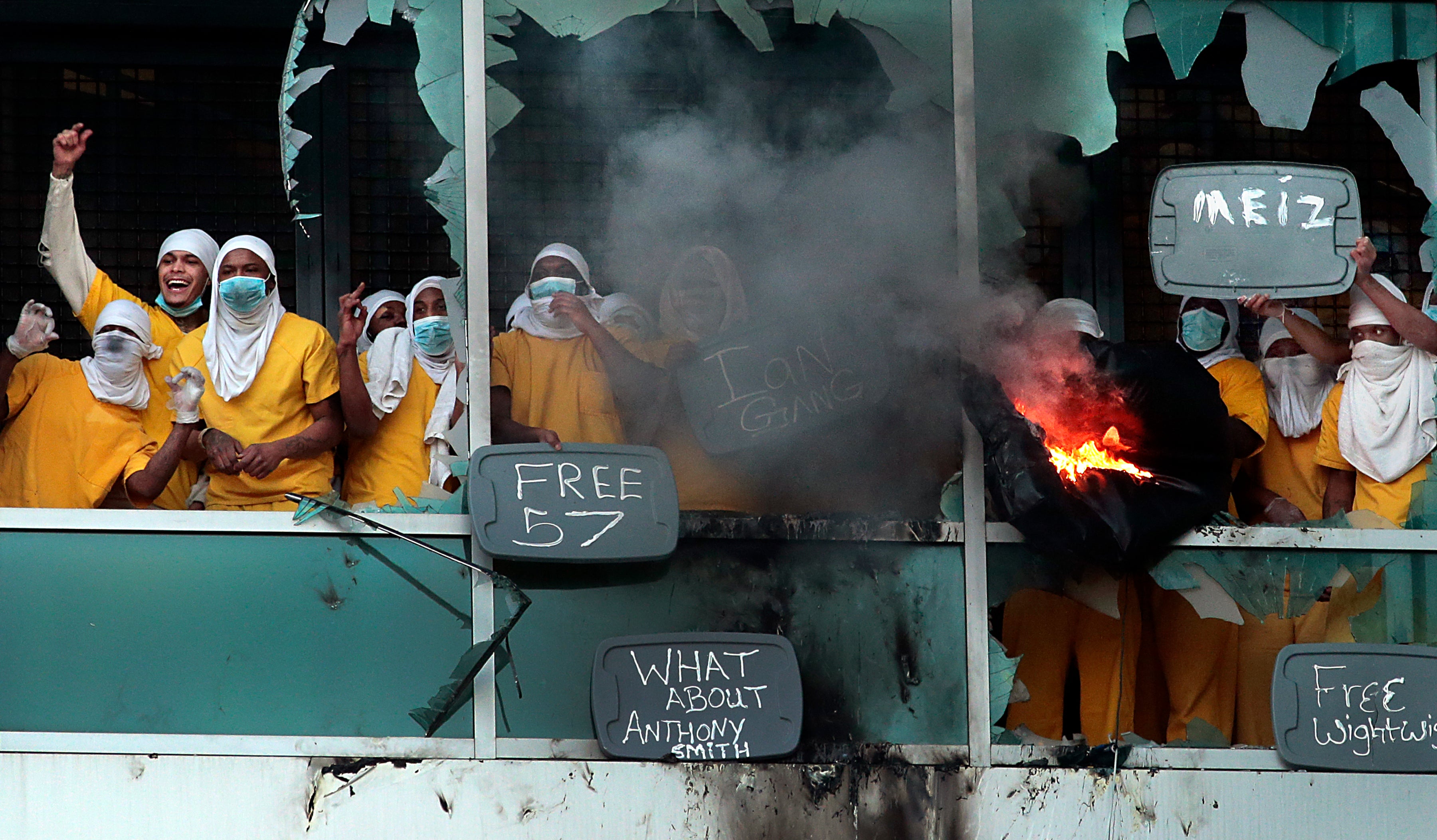 Inmates yell from broken windows at the St Louis Justice Center, known as the city jail, on Saturday 6 February