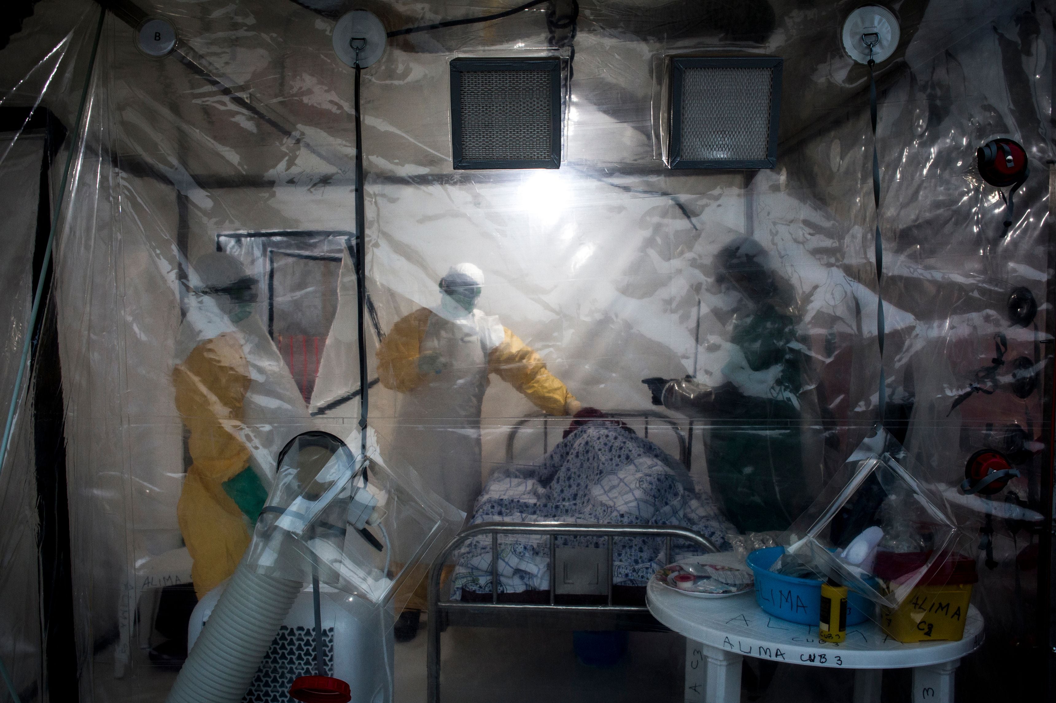 Three medical workers check on an Ebola patient in a Biosecure Emergency care unit in 2018 in Beni, Congo