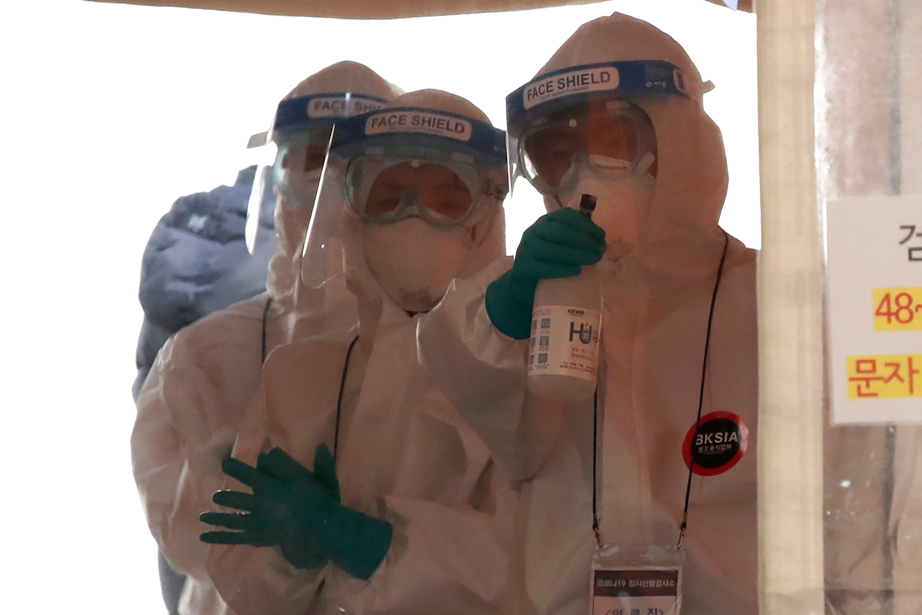 A medical worker wearing protective gear sprays disinfectant at a coronavirus testing site in Seoul, South Korea