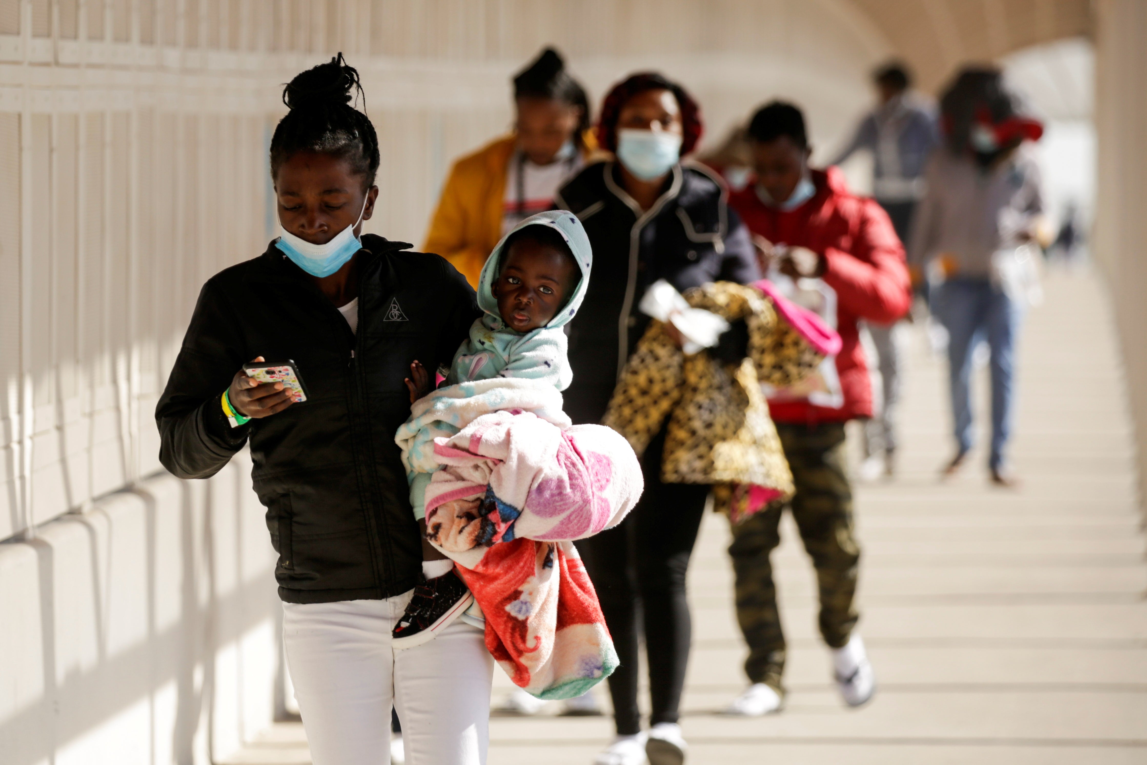 Migrants from Haiti walk across the Zaragoza-Ysleta international border bridge after being deported from the United States, in Ciudad Juarez, Mexico.