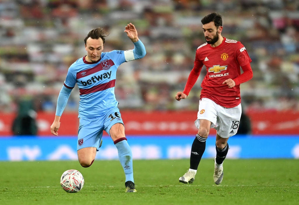 Mark Noble of West Ham is put under pressure by Bruno Fernandes