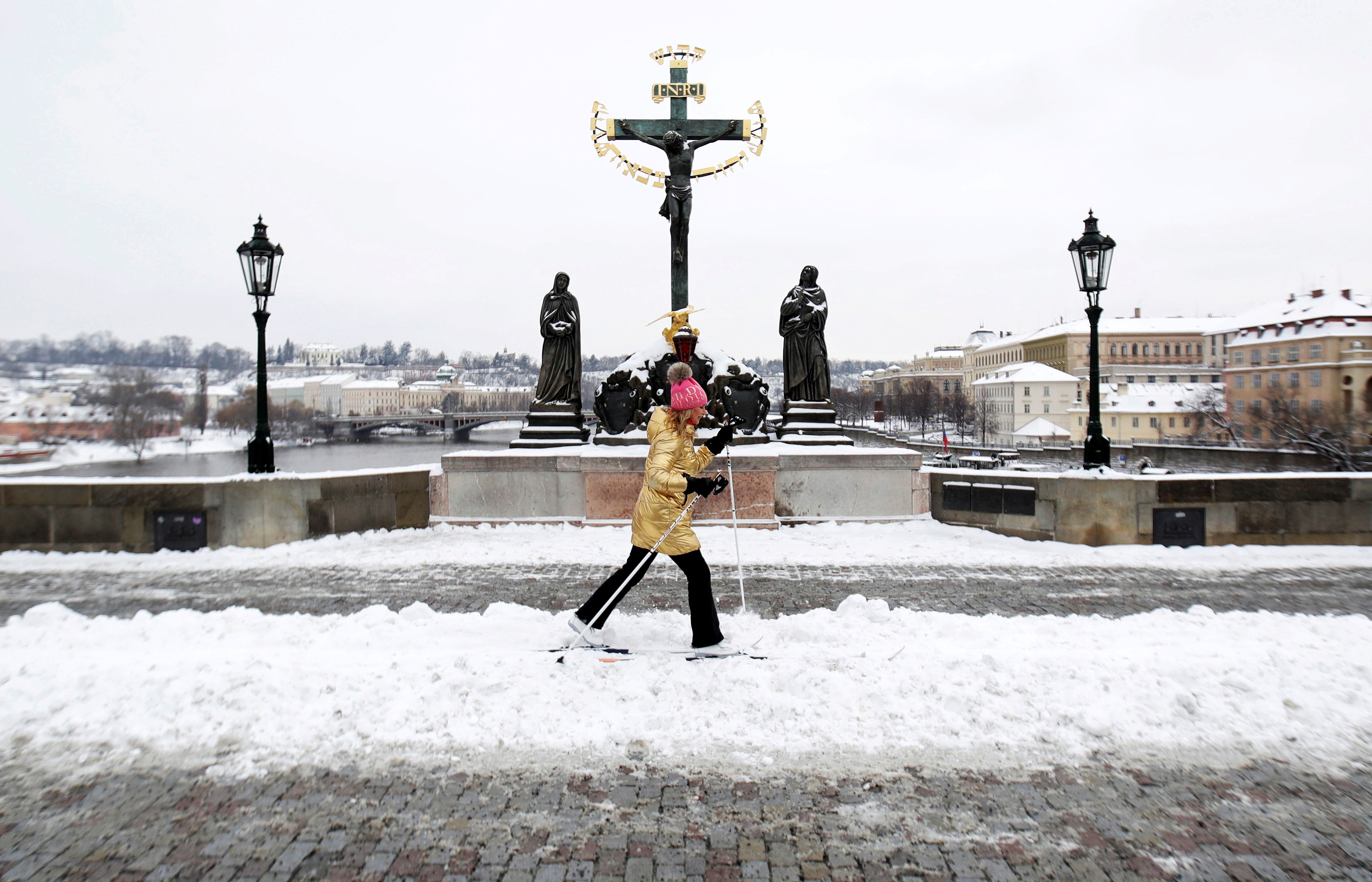 A woman cross-country skis across the medieval Charles Bridge in Prague, Czech Republic