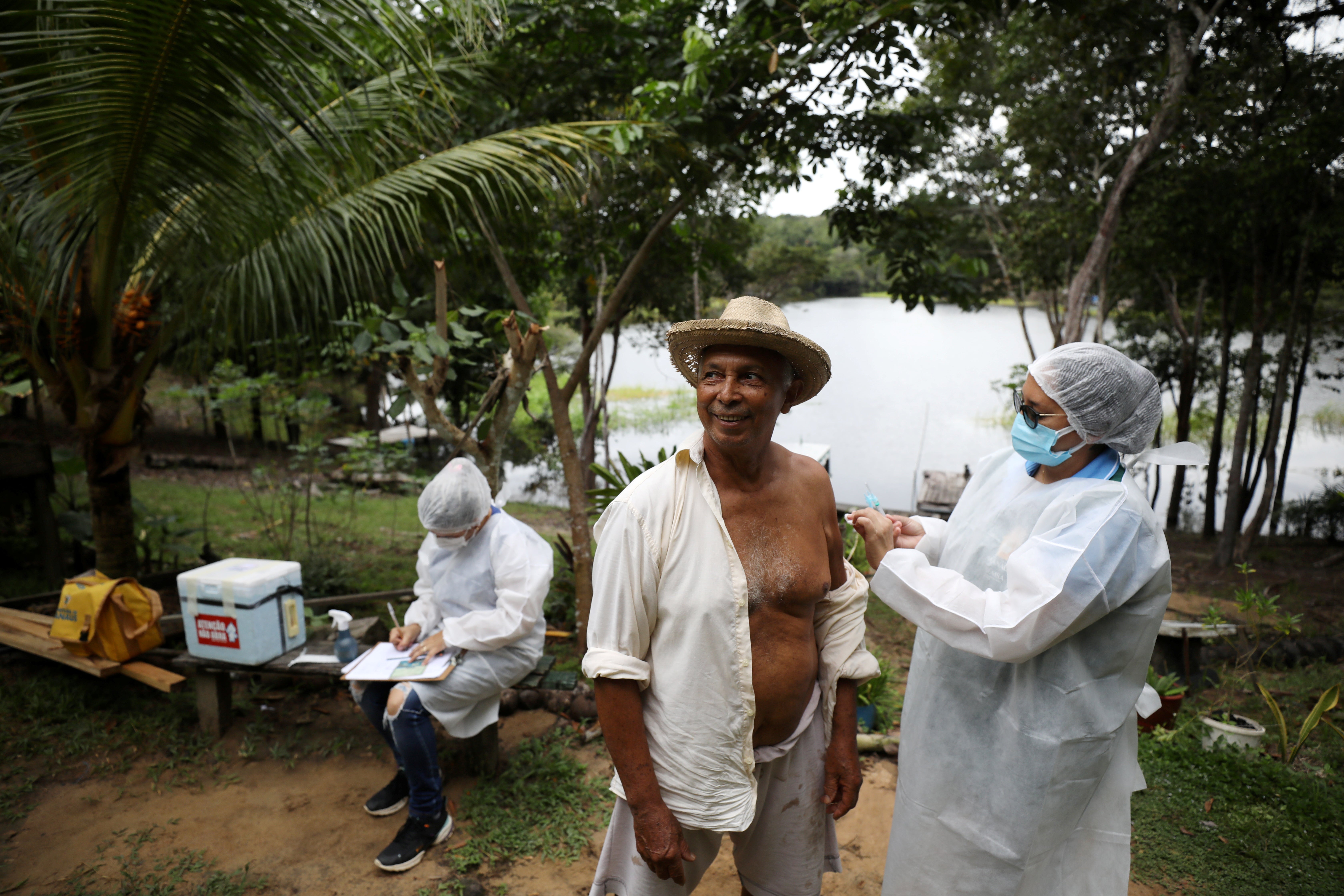 Antonio Valente, 72, receives the AstraZeneca/Oxford vaccine from a municipal health worker in Manaus, Brazil