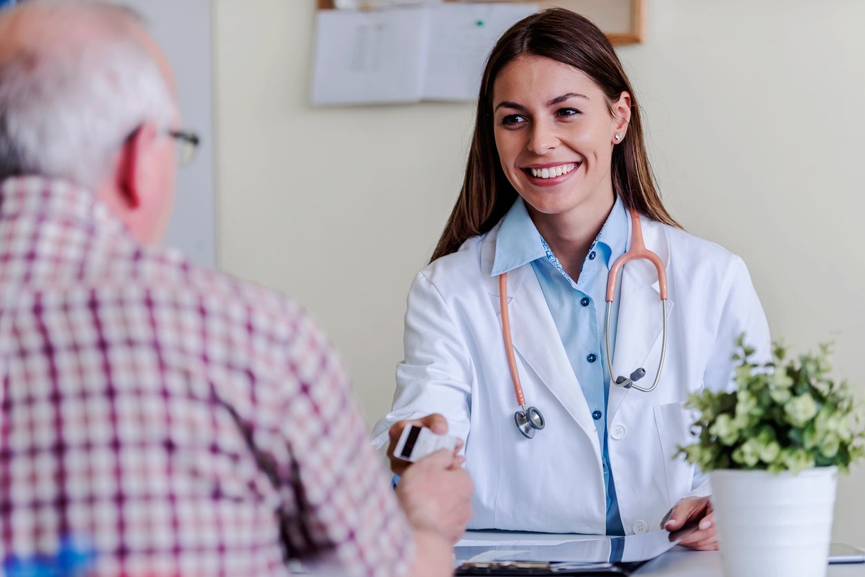 Older patient pays a doctor after a medical examination