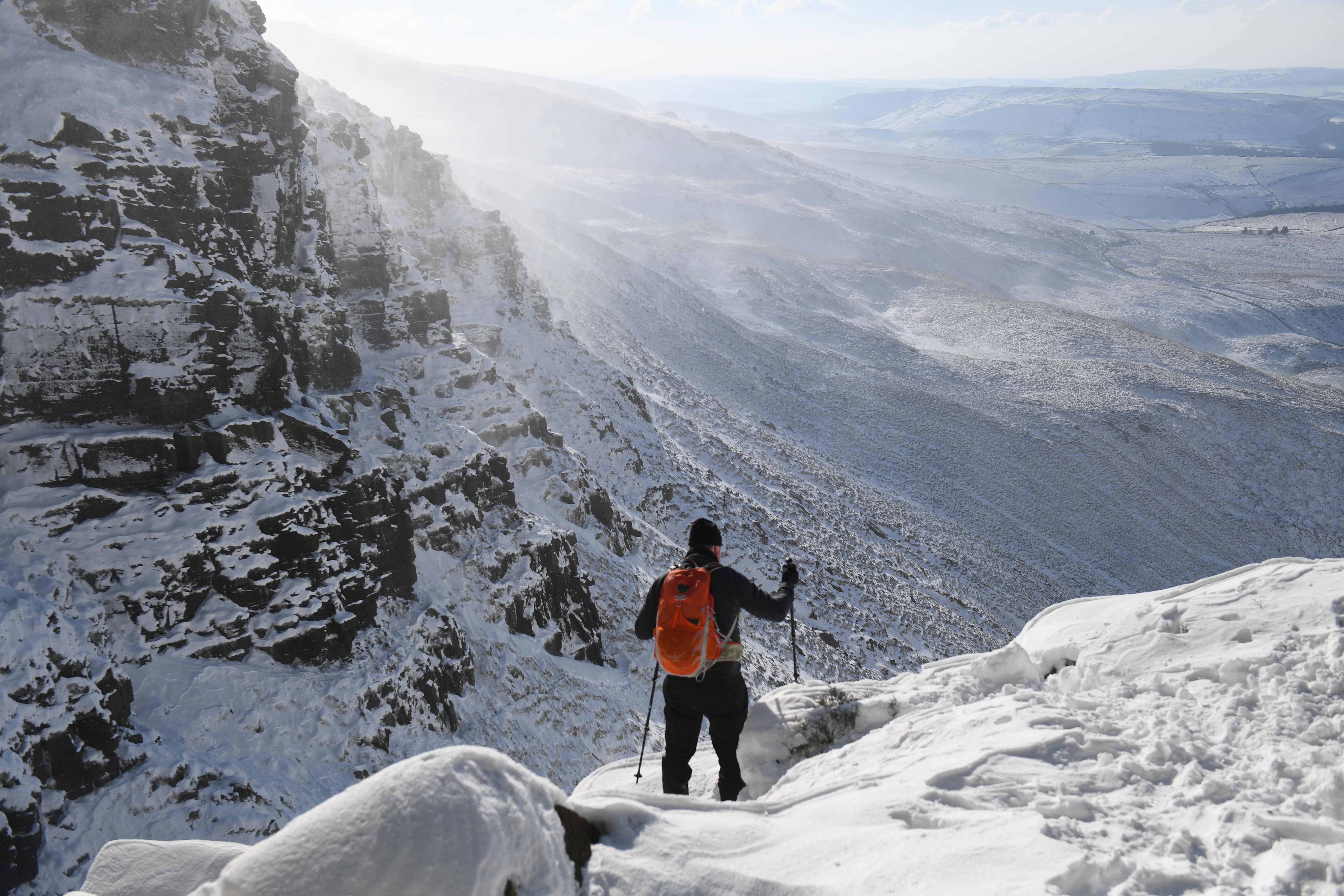 A climber is seen on the Kinder Scout plateau in the Peak District National Park near Hayfield, northwest England as snow blankets the region on February 12, 2021